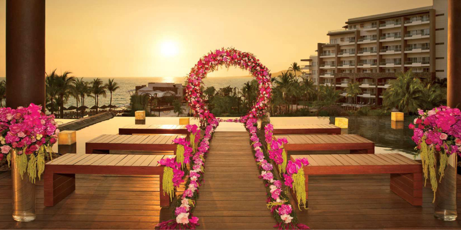 A wedding ceremony set up on a wooden deck overlooking the ocean at Dreams Vallarta Bay.