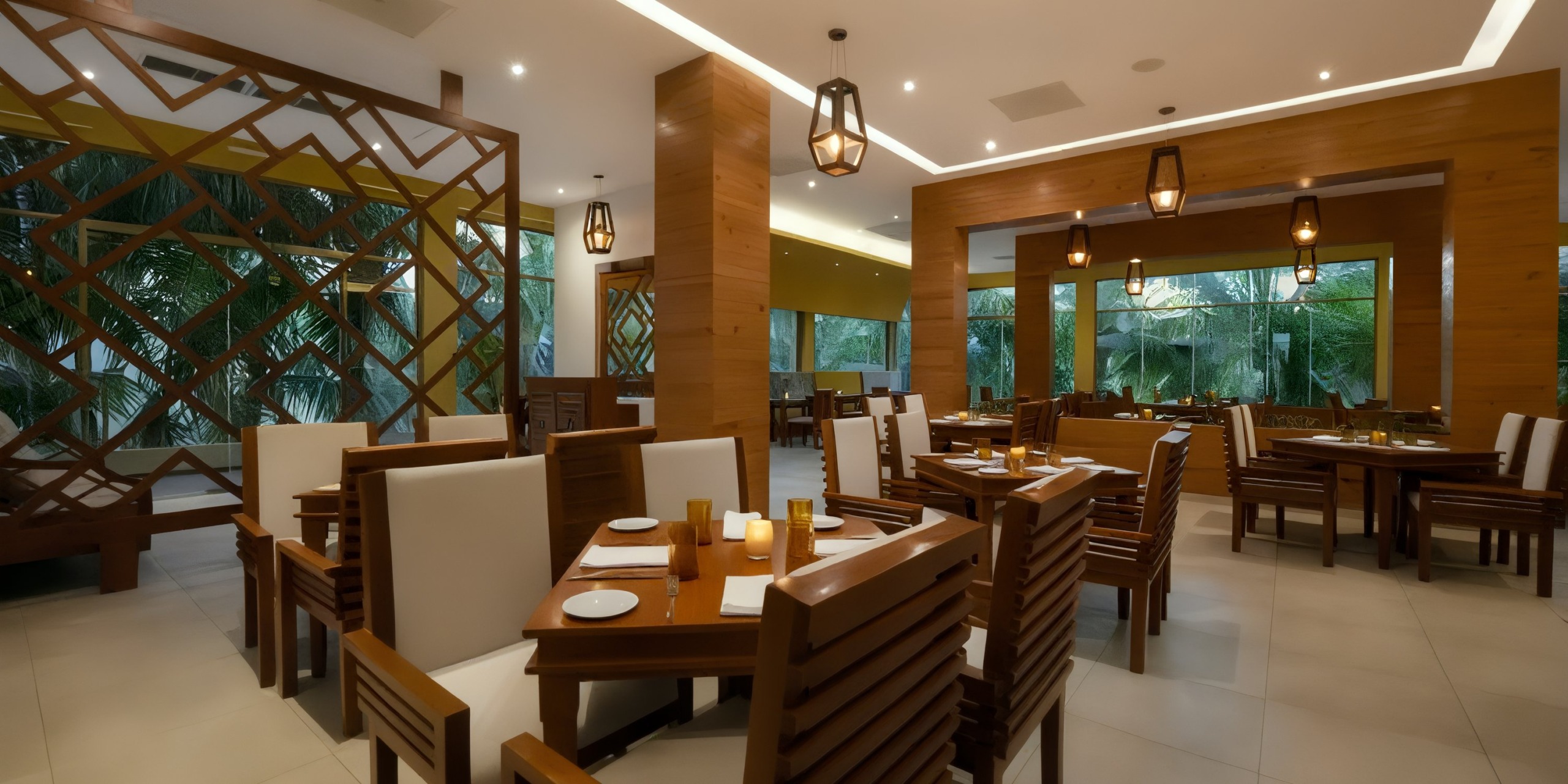 Experience the modern interior of El Dorado Maroma, featuring wooden furniture, white cushioned chairs, and warm lighting. Large windows provide views of lush greenery outside.