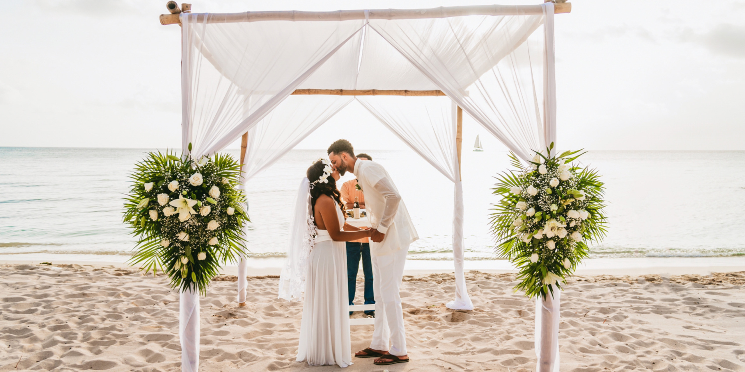 Gabby and Steven the groom kisses the bride at the end of their dream beach wedding