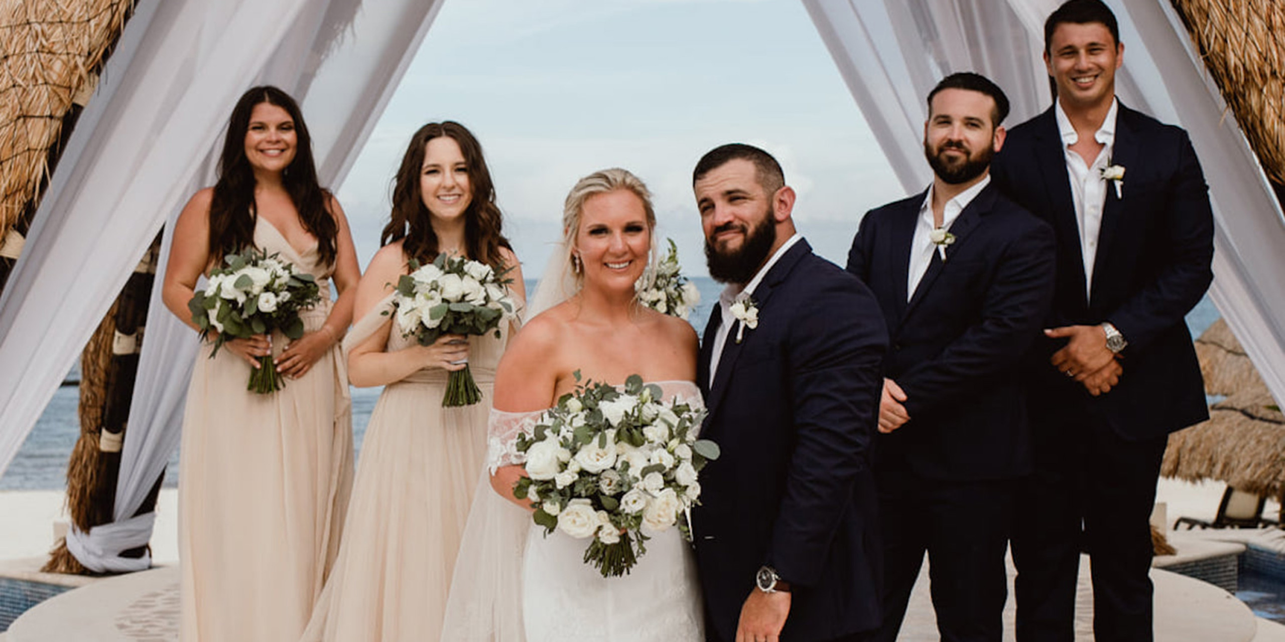 Hannah and Ben pose with their wedding party groomsmen and bridesmaids