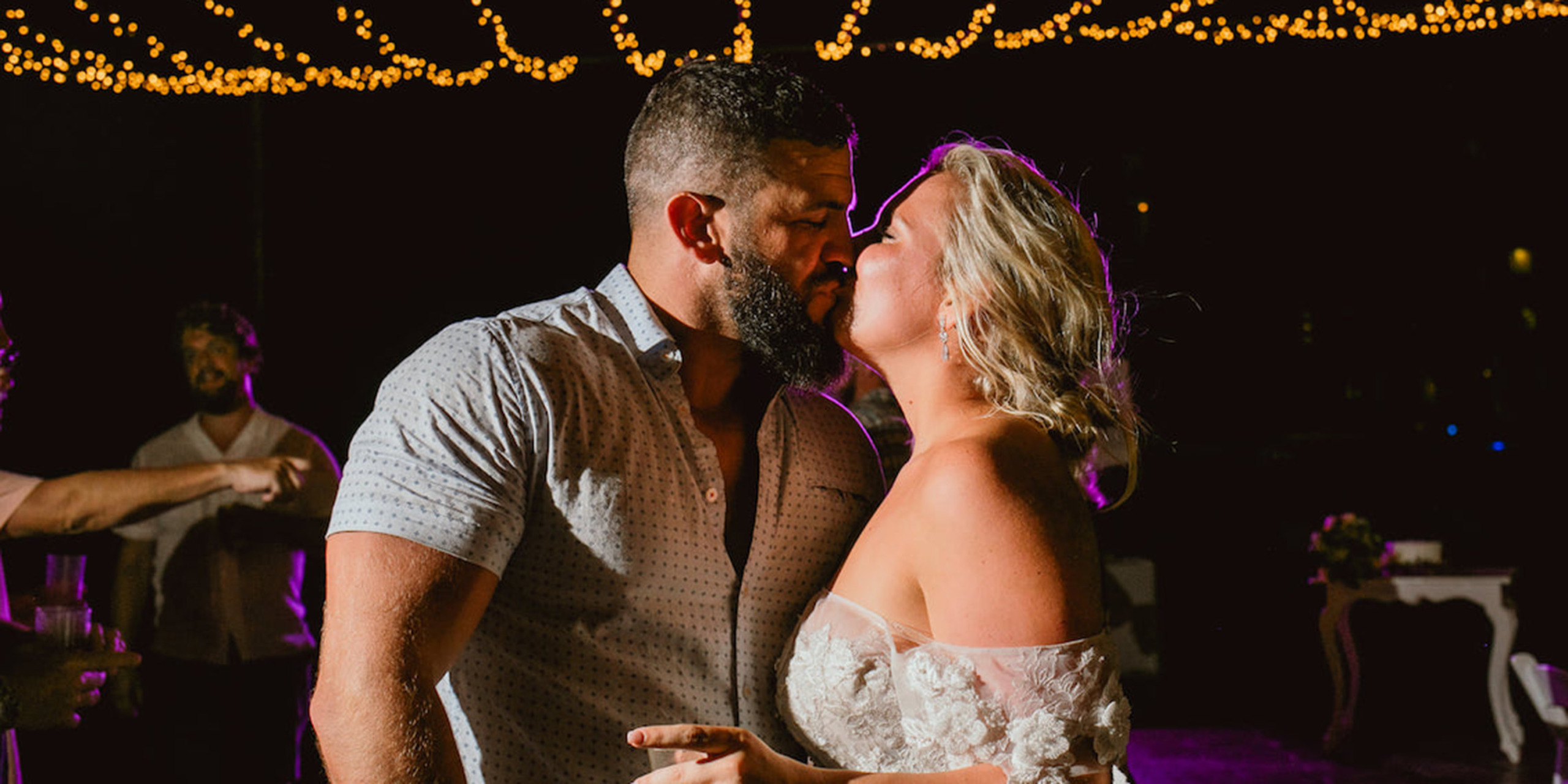 Hannah and Ben smooch while celebrating their destination wedding at their wedding reception