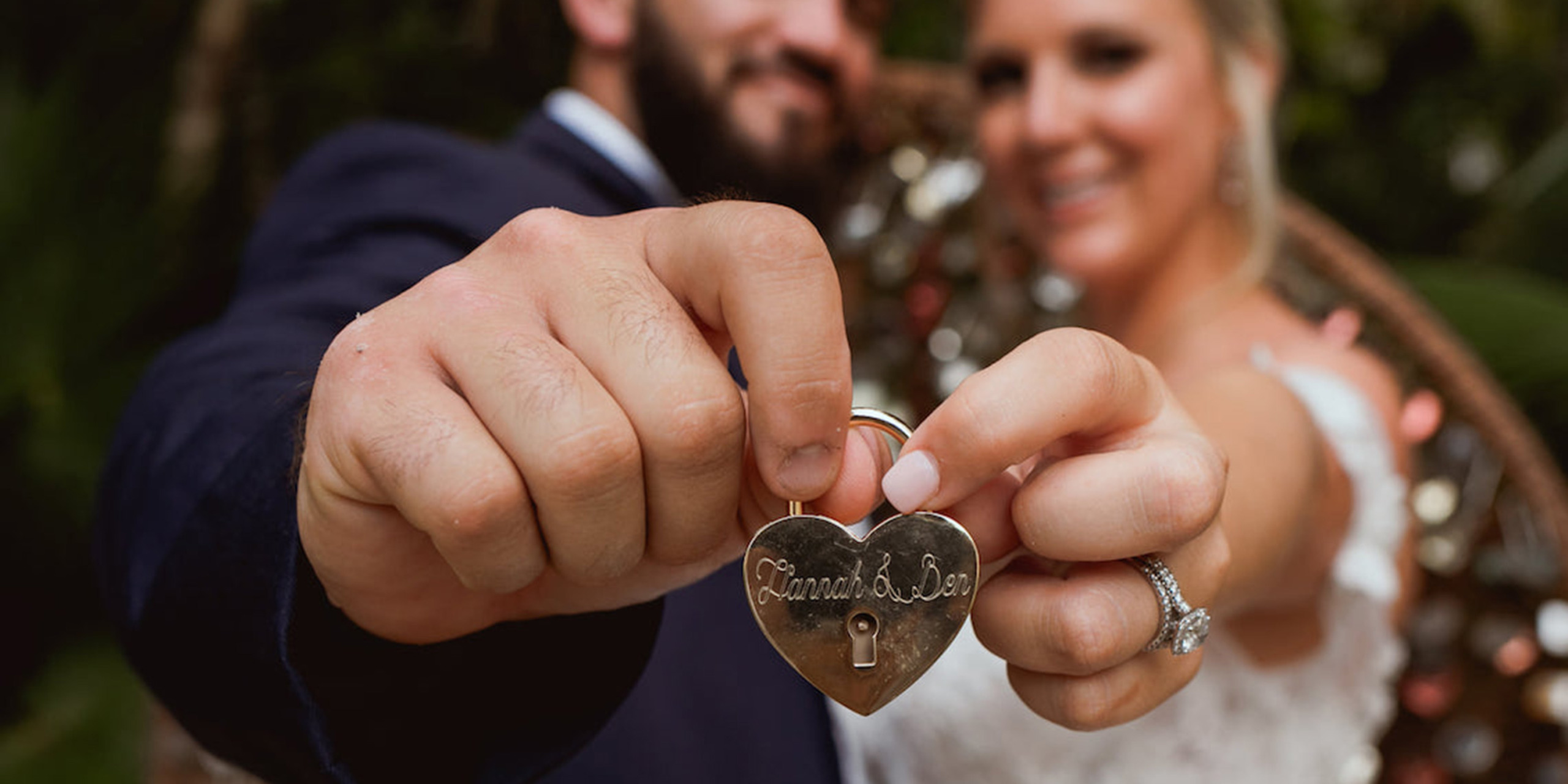 Hannah and Ben hold up a love padlock with their names on it