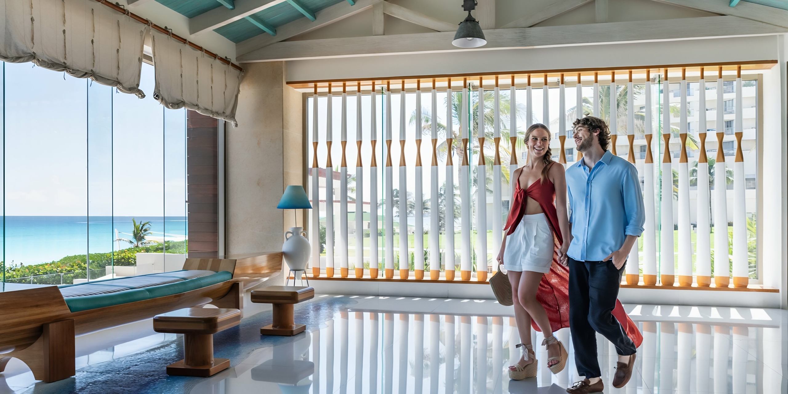 A couple walking together through a bright and modern Iberostar Selection Cancun interior.
