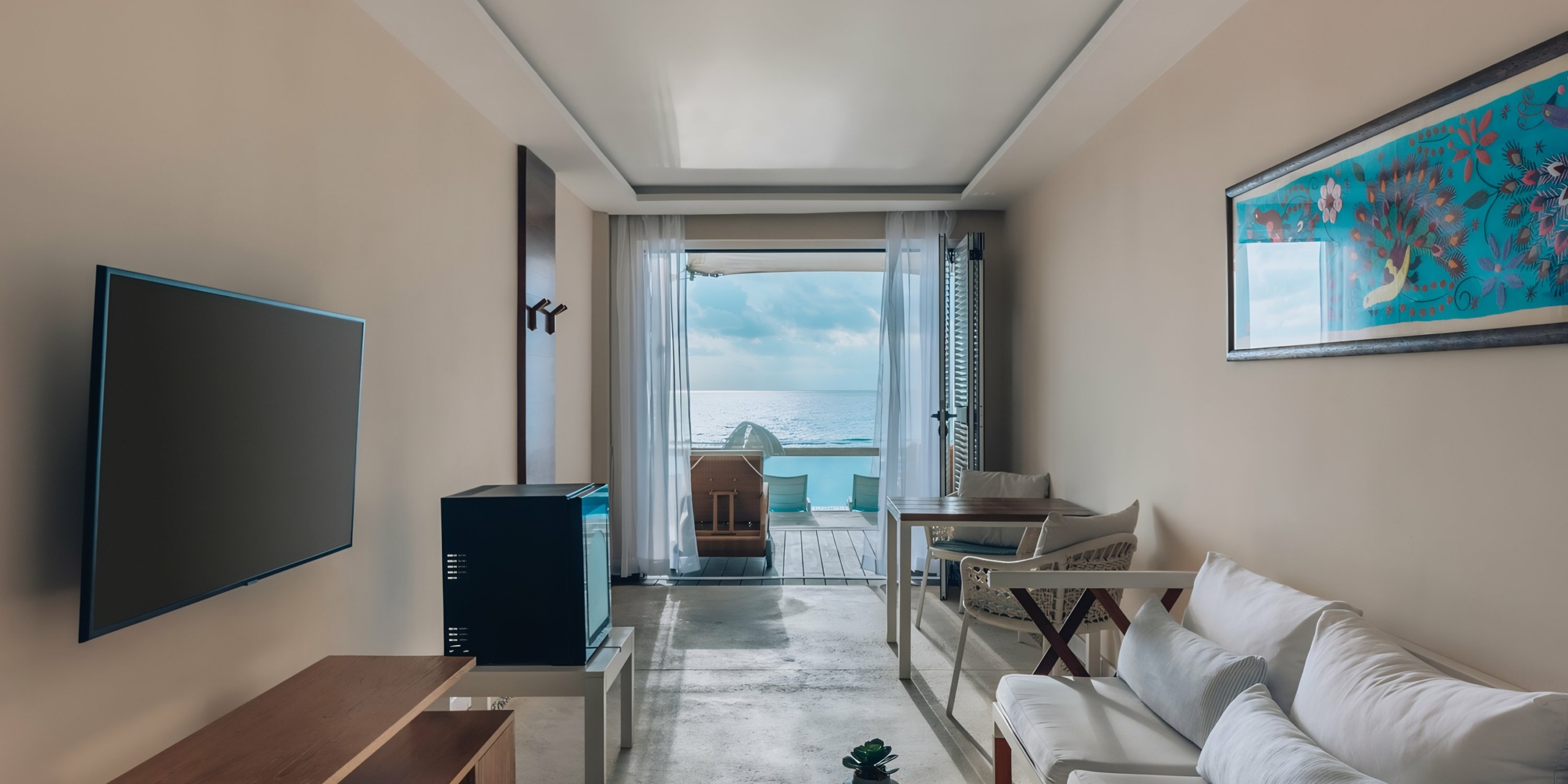 Iberostar Selection Cancun hotel room with a minimalist design opening onto an ocean view balcony.