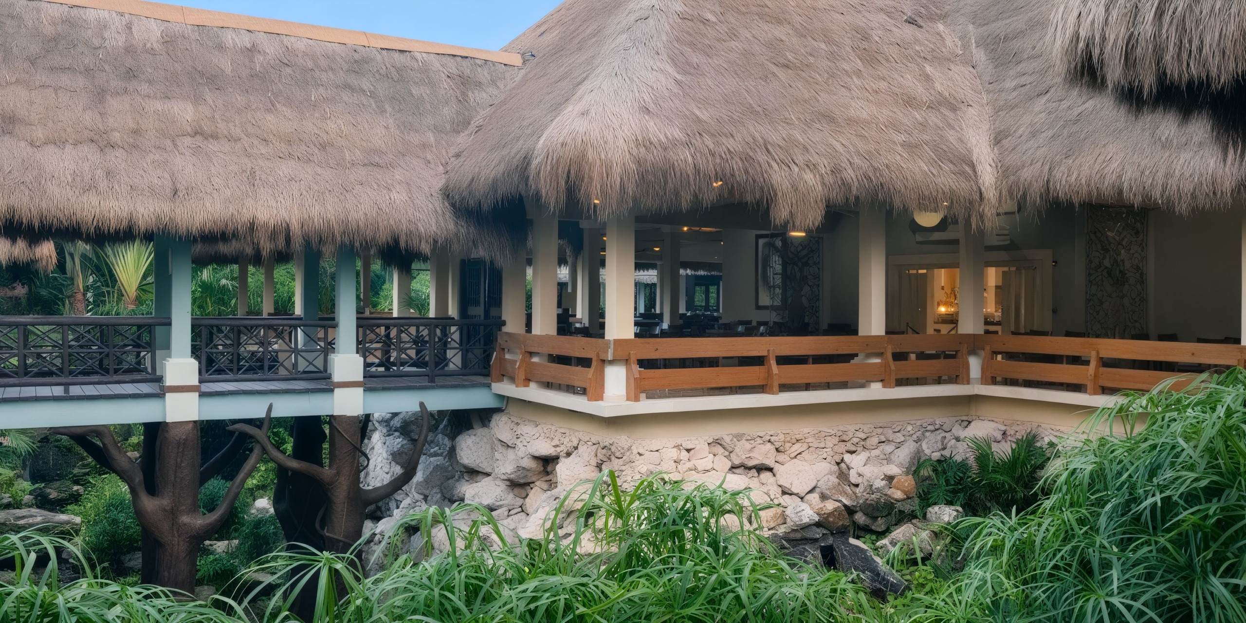The Iberostar Waves Quetzal is a thatched-roof building with wooden railings set in a lush, tropical environment.