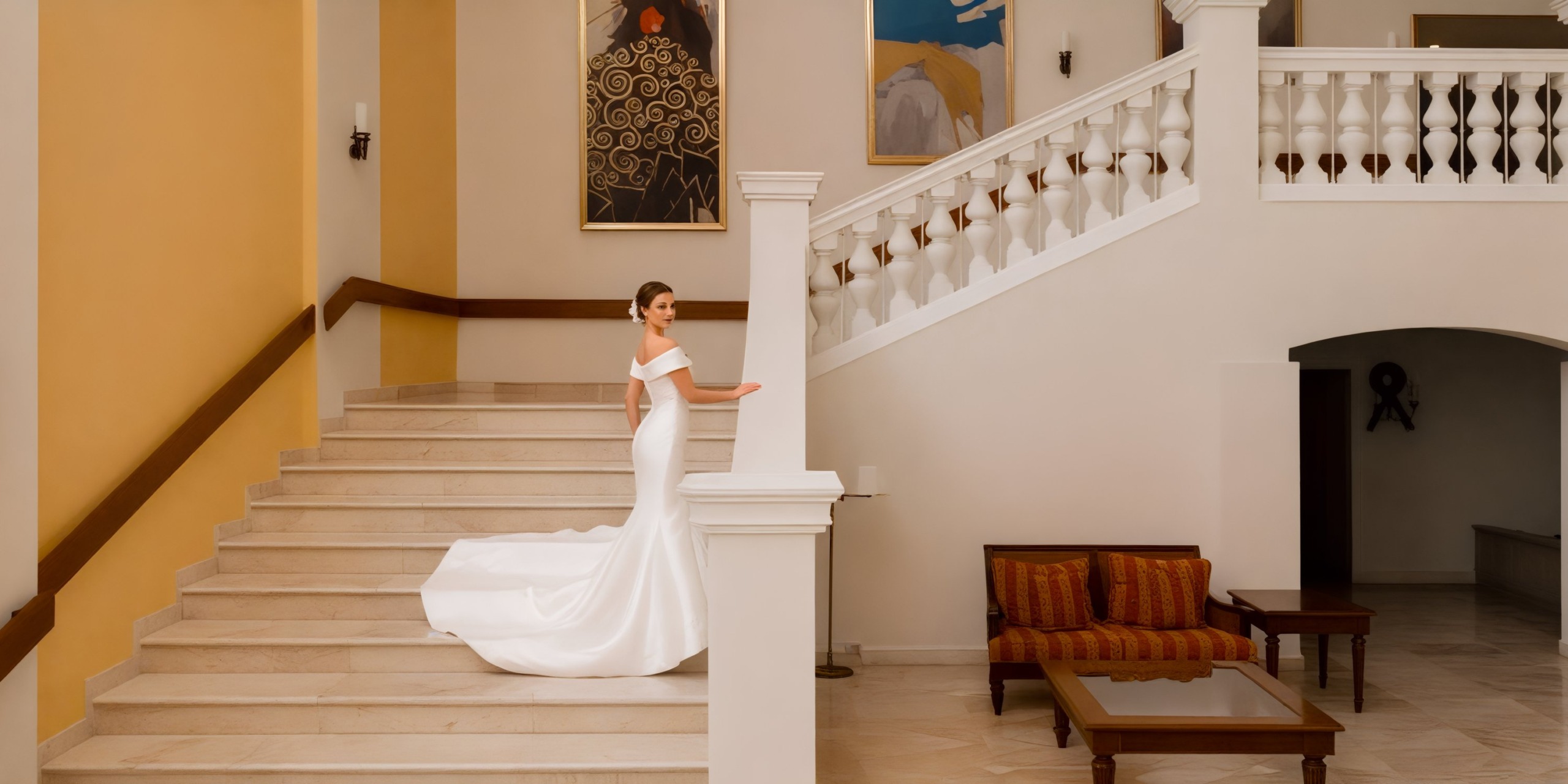 A bride in a stunning white gown stands gracefully beside the cream wall display at Iberostar Waves Rose Hall Beach, creating a picture-perfect moment for her destination wedding.