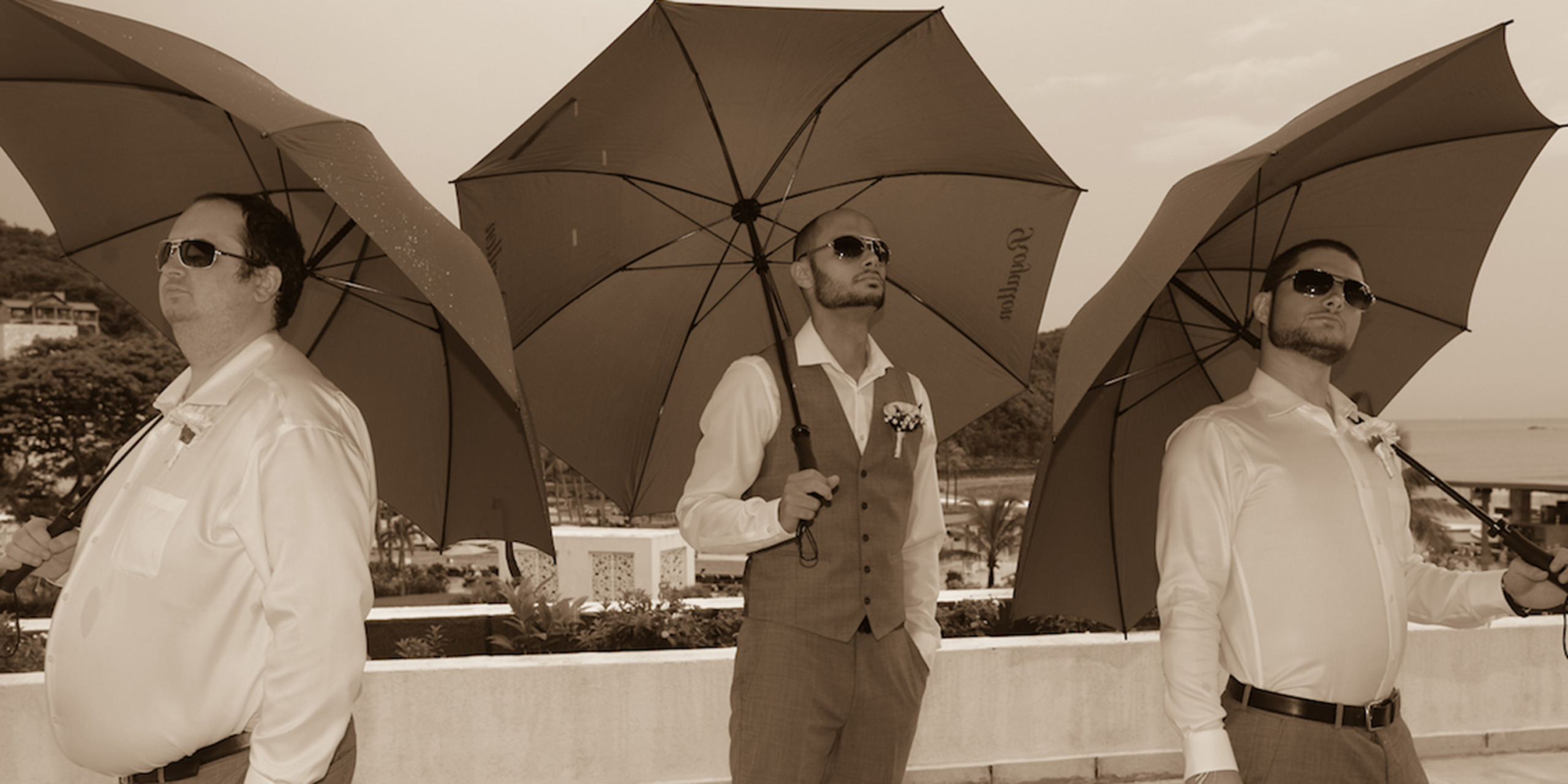 Igor poses with umbrellas with his groomsmen at the India and Igor destination wedding