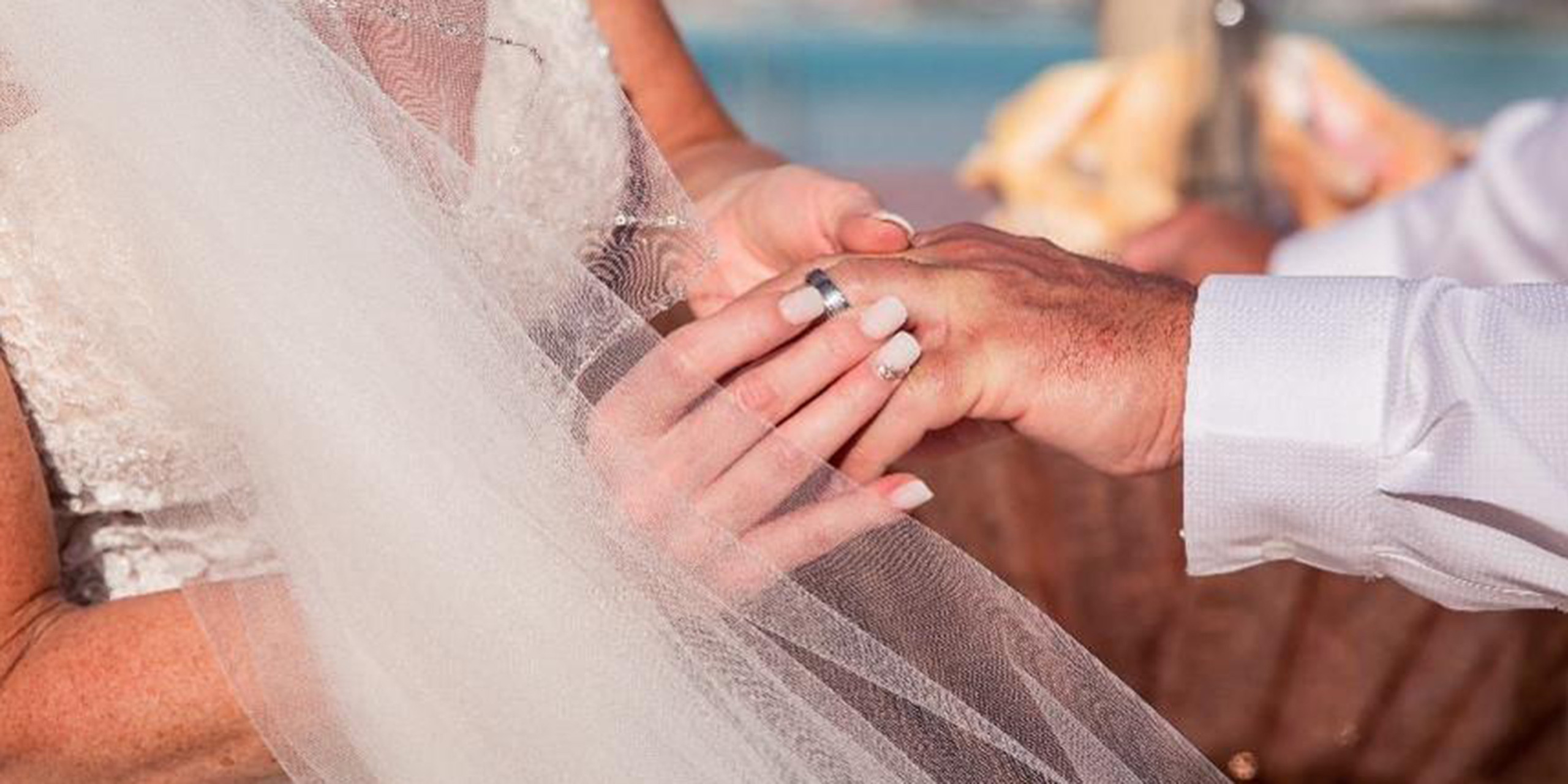 Jacqueline puts the wedding ring onto and Troy's finger