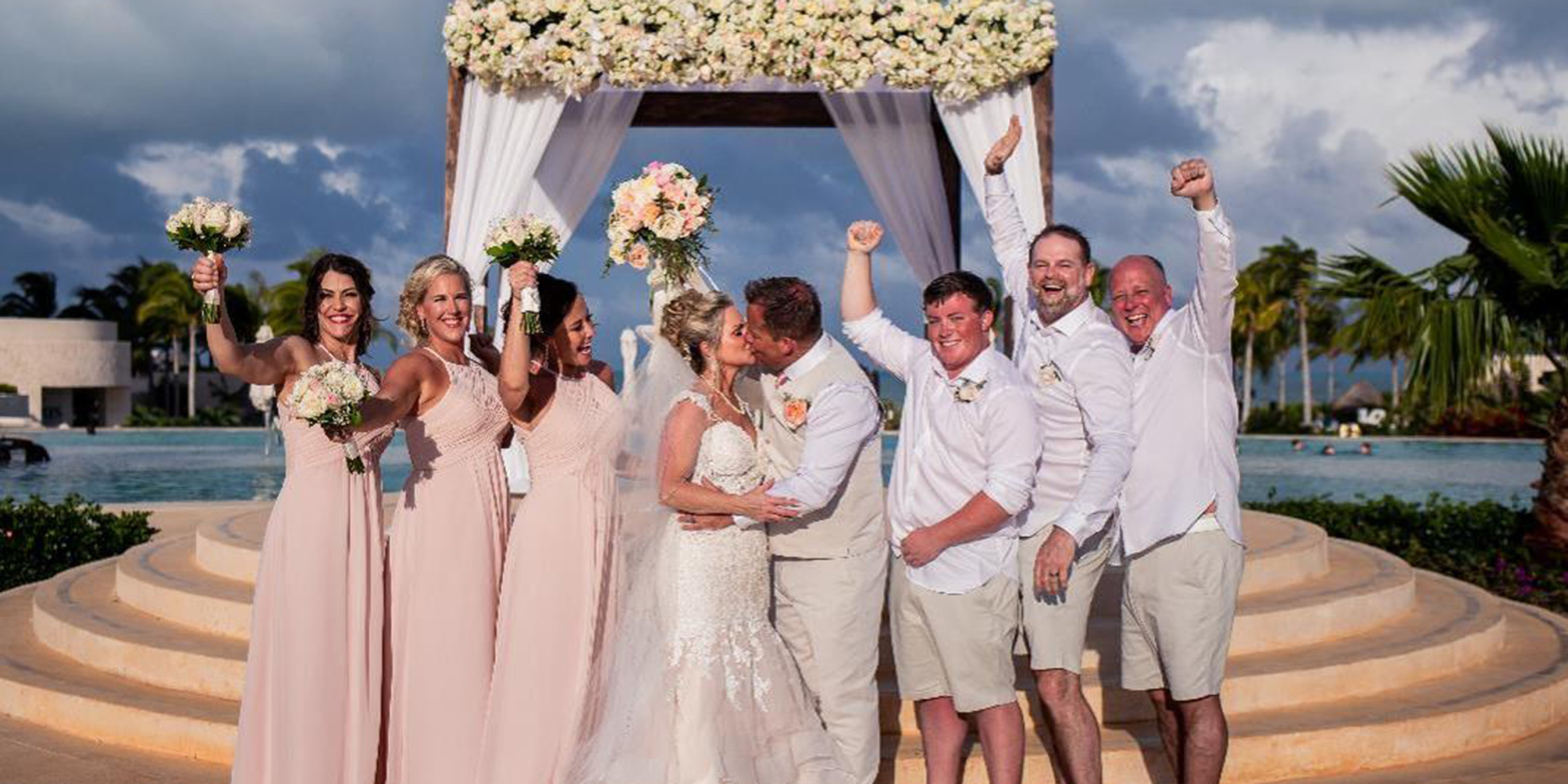 Jacqueline and Troy kiss with all their funny friends and family bridesmaids and groomsmen and son