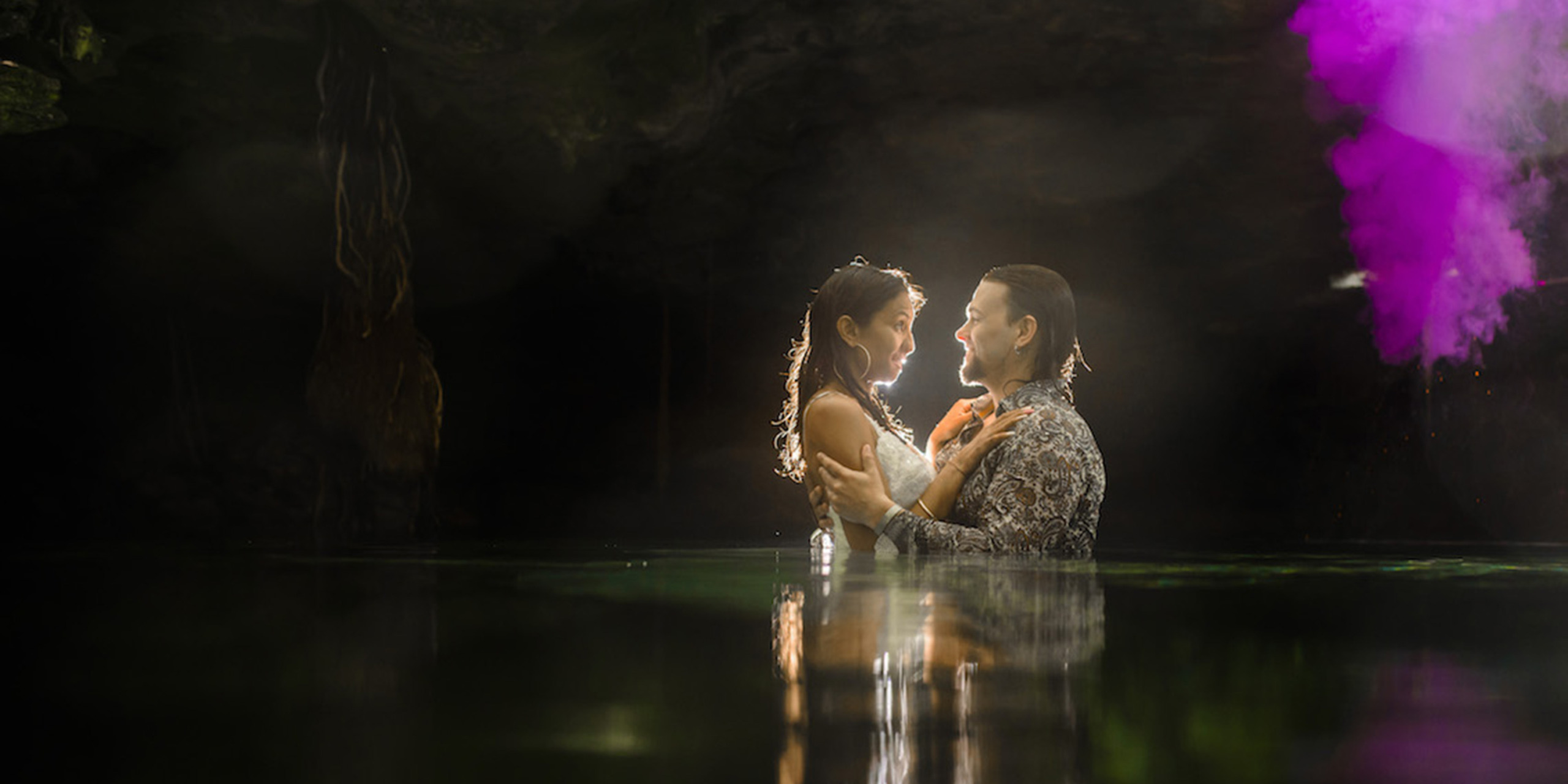 Jason and Priya embrace in the jungle in a pond