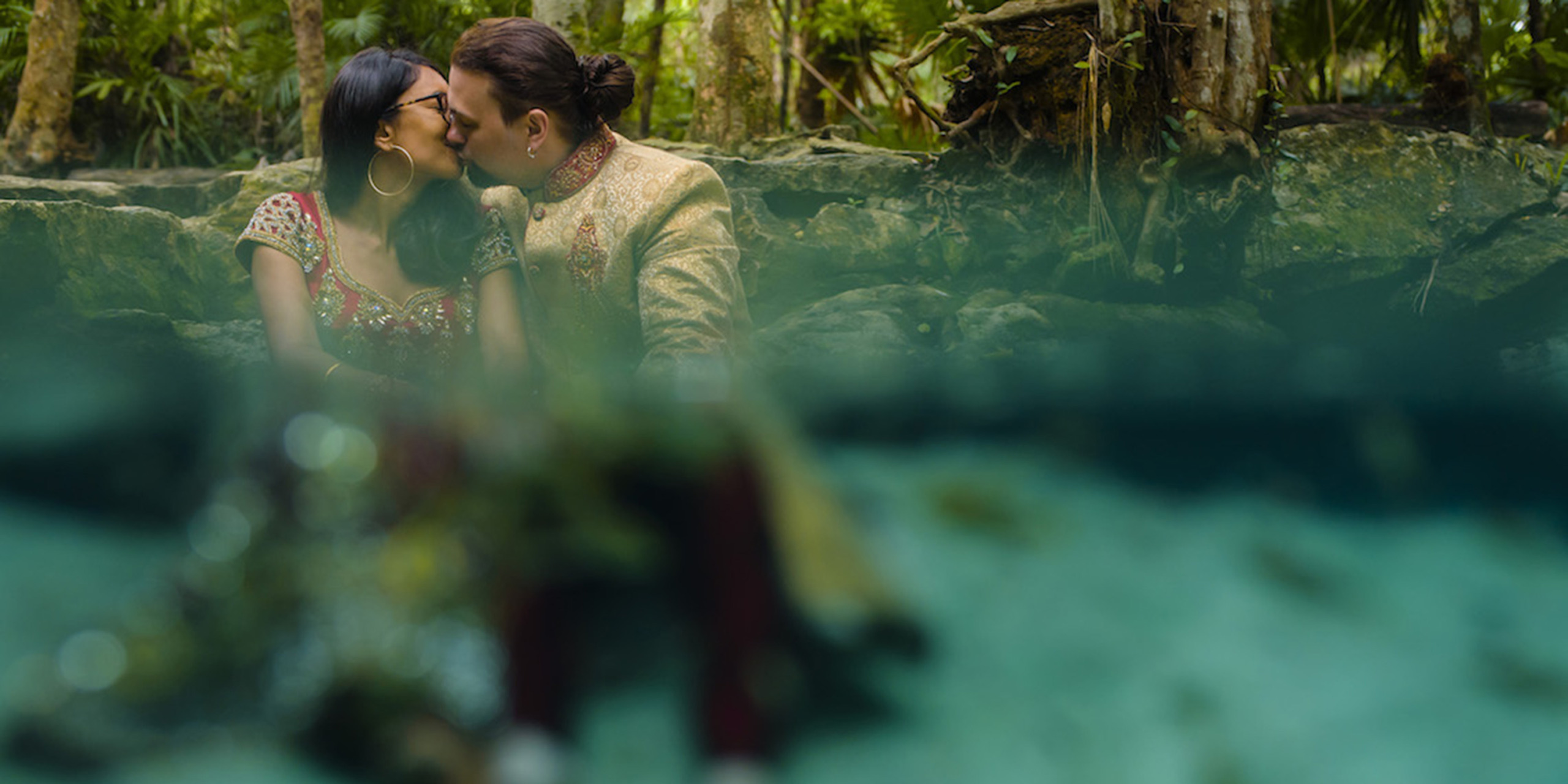 Jason and Priya kiss in the jungle in a pond