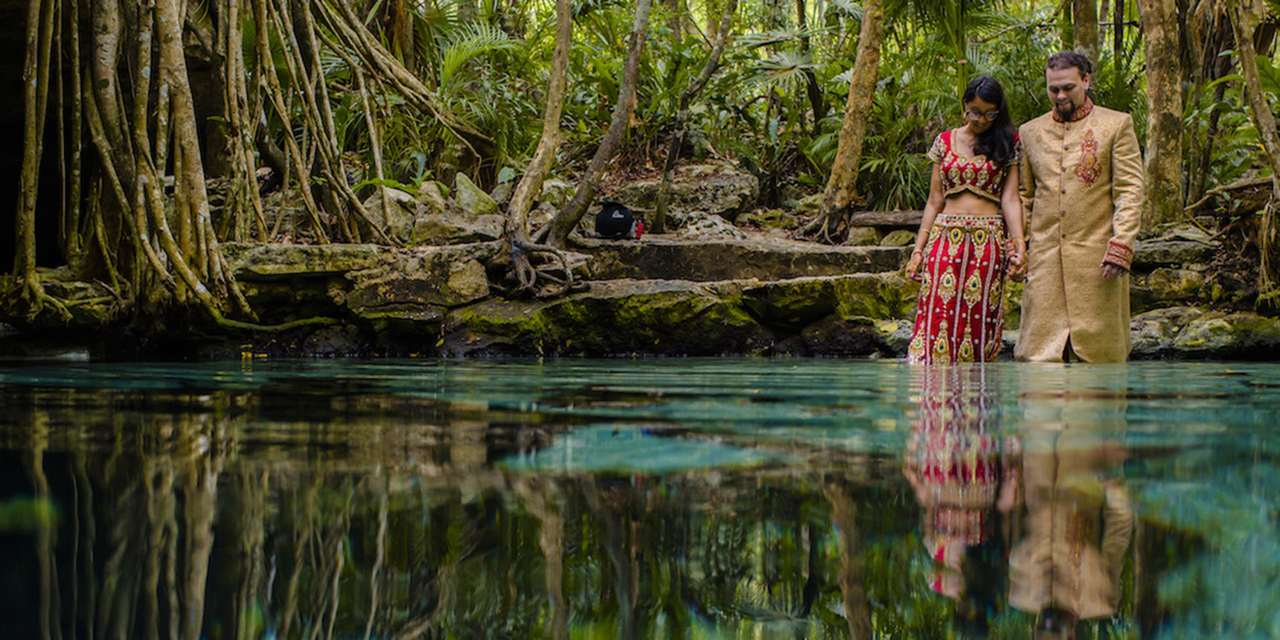 Jason and Priya kiss in the jungle by a pond
