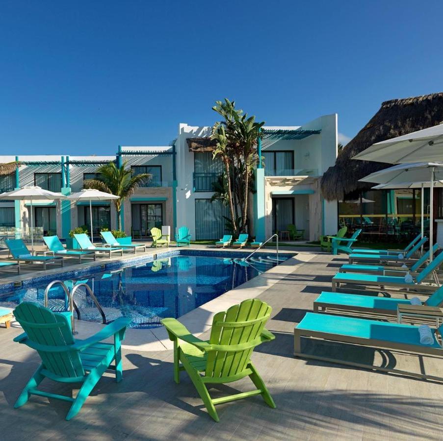 A Margaritaville Beach Resort Riviera Cancun with lounge chairs, umbrellas, and wedding decorations.