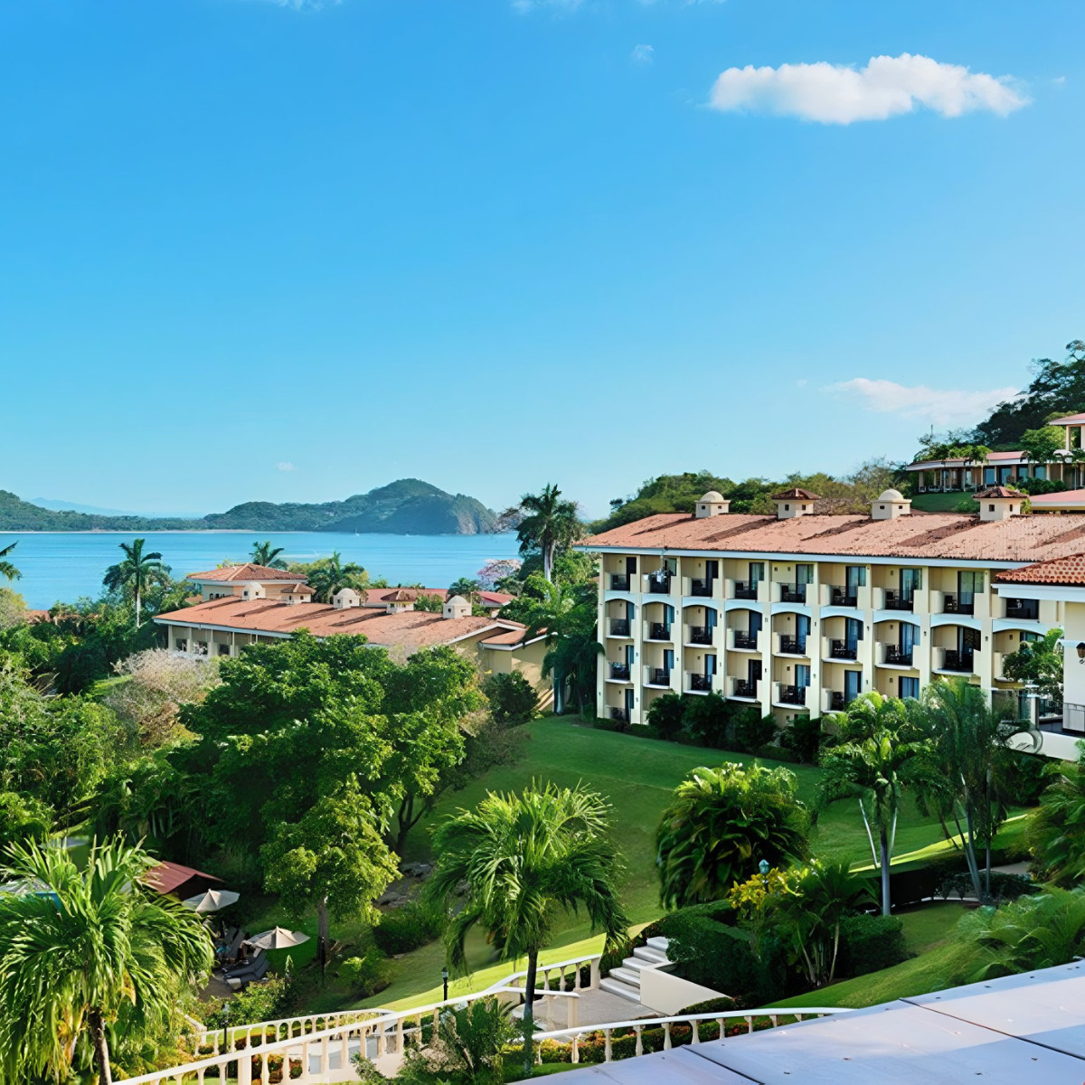 A coastal resort with Occidental Papagayo, ideal for a destination wedding, surrounded by lush greenery overlooking a serene blue bay.