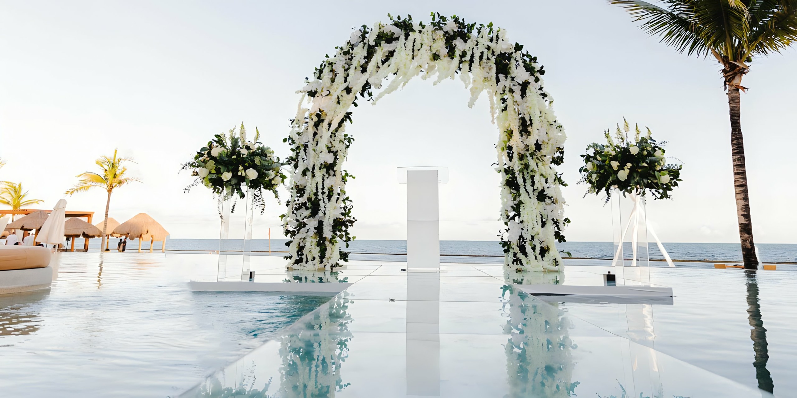 A Breathless Riviera Cancún Resort & Spa with white flowers in front of a pool.