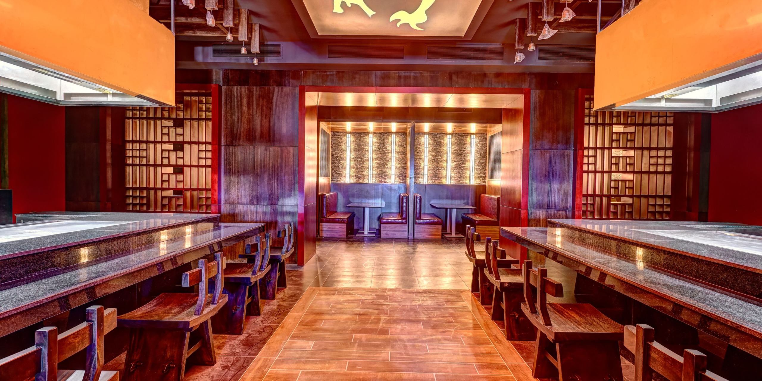 The interior of Planet Hollywood Costa Rica features wooden tables and chairs, bright lighting, and decorative wall panels, all contributing to its sleek, contemporary design.