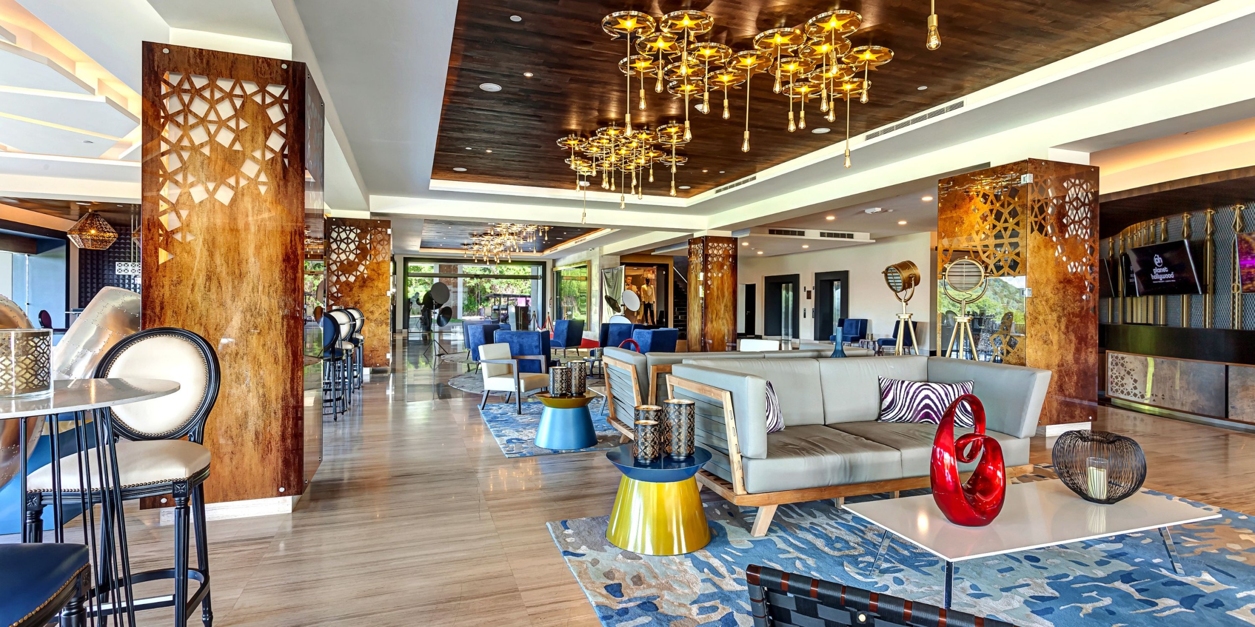 The Planet Hollywood Costa Rica boasts a modern hotel lobby featuring stylish seating, decorative lighting, and vibrant accents.