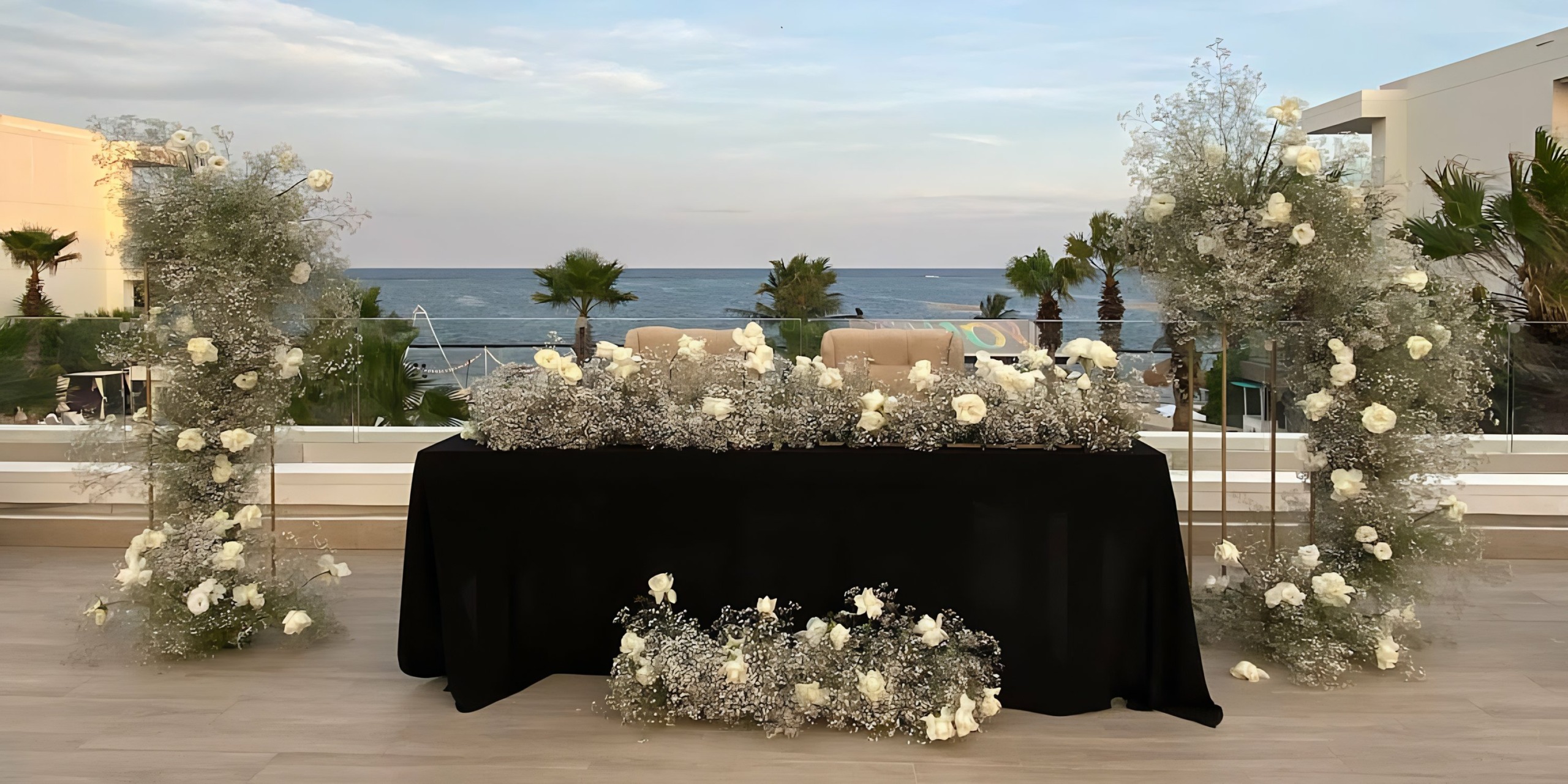 A table set up with white flowers and a view of the ocean at Breathless Riviera Cancún Resort & Spa.