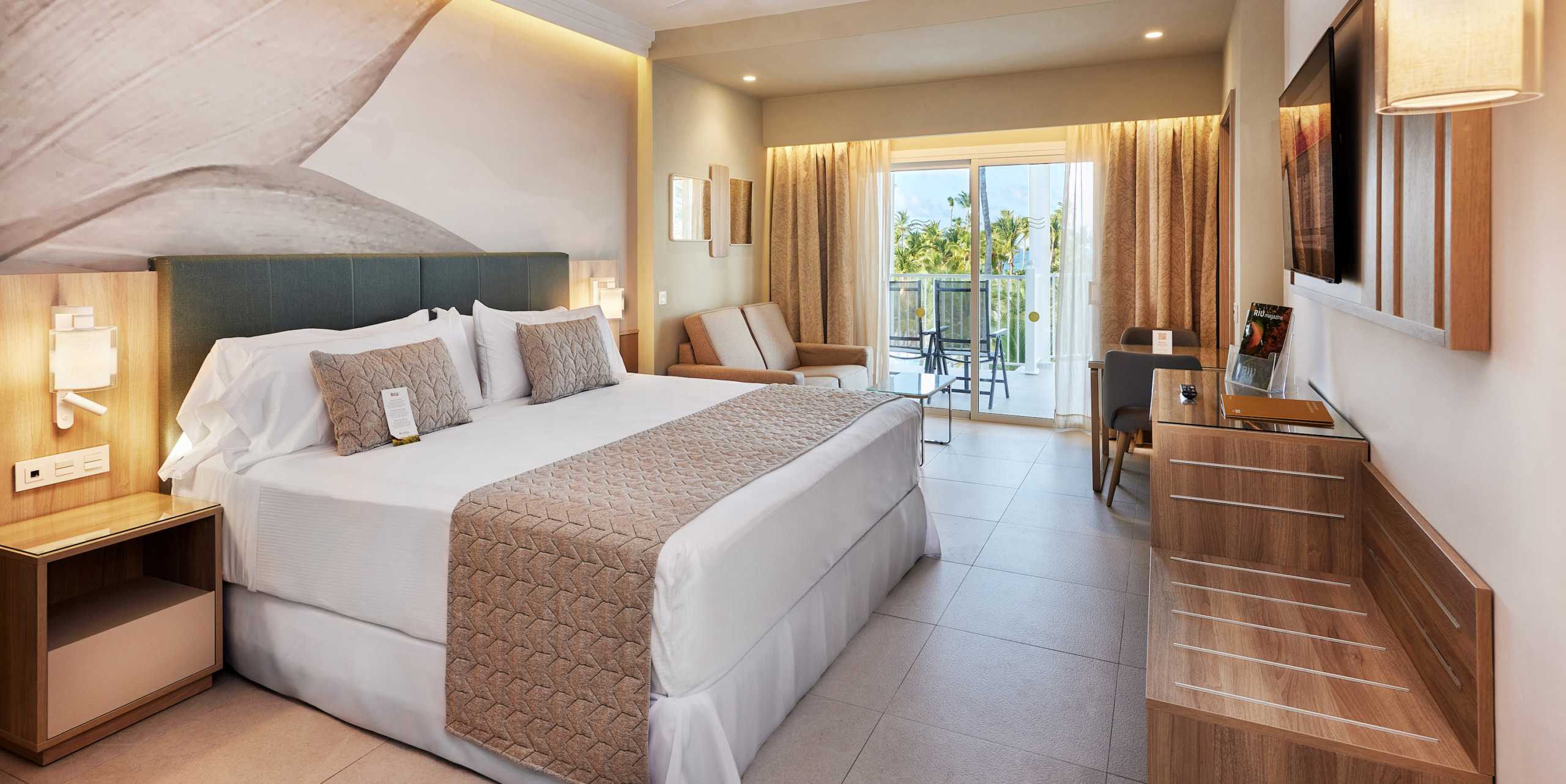 Hotel Riu Palace Macao room with a large bed and a balcony.