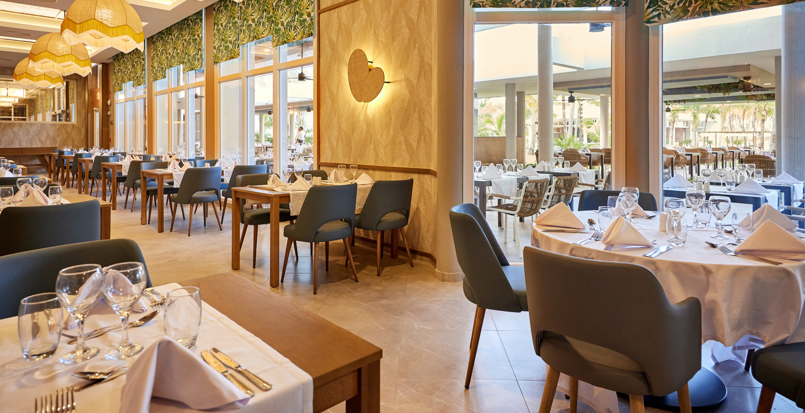 A restaurant with tables and chairs in the middle of the room becomes A Hotel Riu Palace Macao with tables and chairs in the middle of the room.