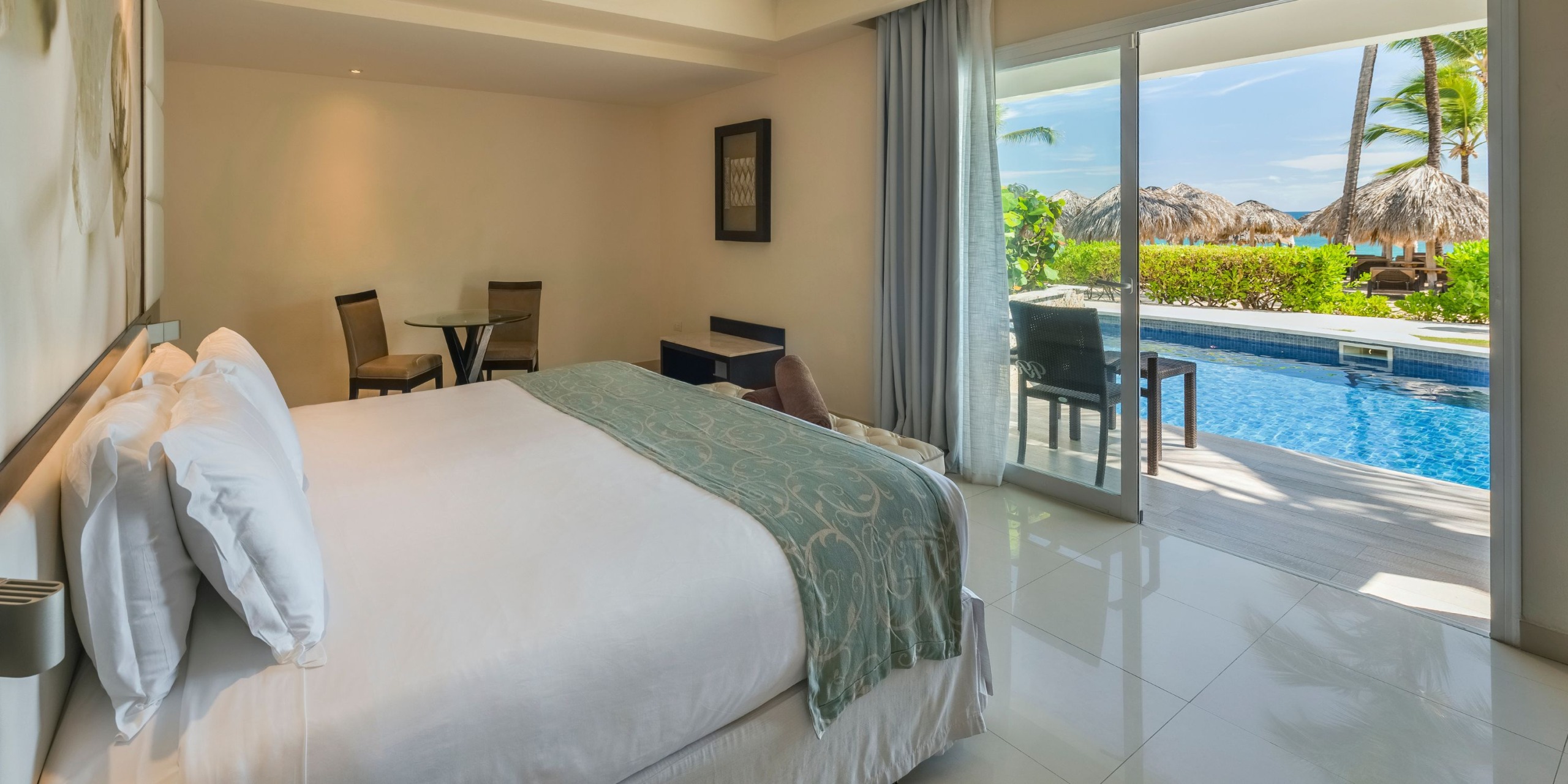 Royalton Punta Cana offers a room featuring a bed, seating area, and sliding glass door that opens to a private pool and patio with stunning ocean views.