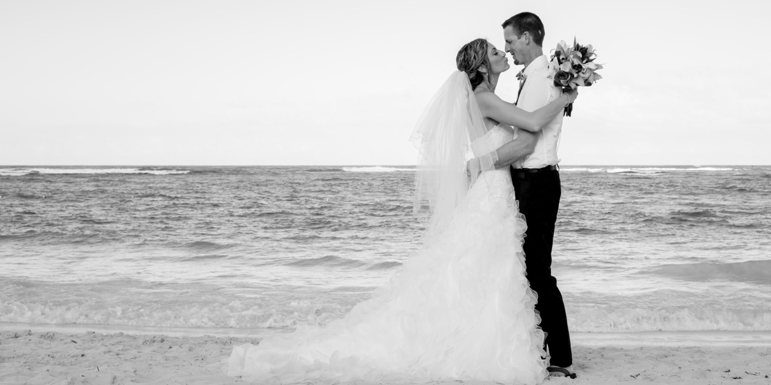 Sonja and Eric embrace and kiss on the beach