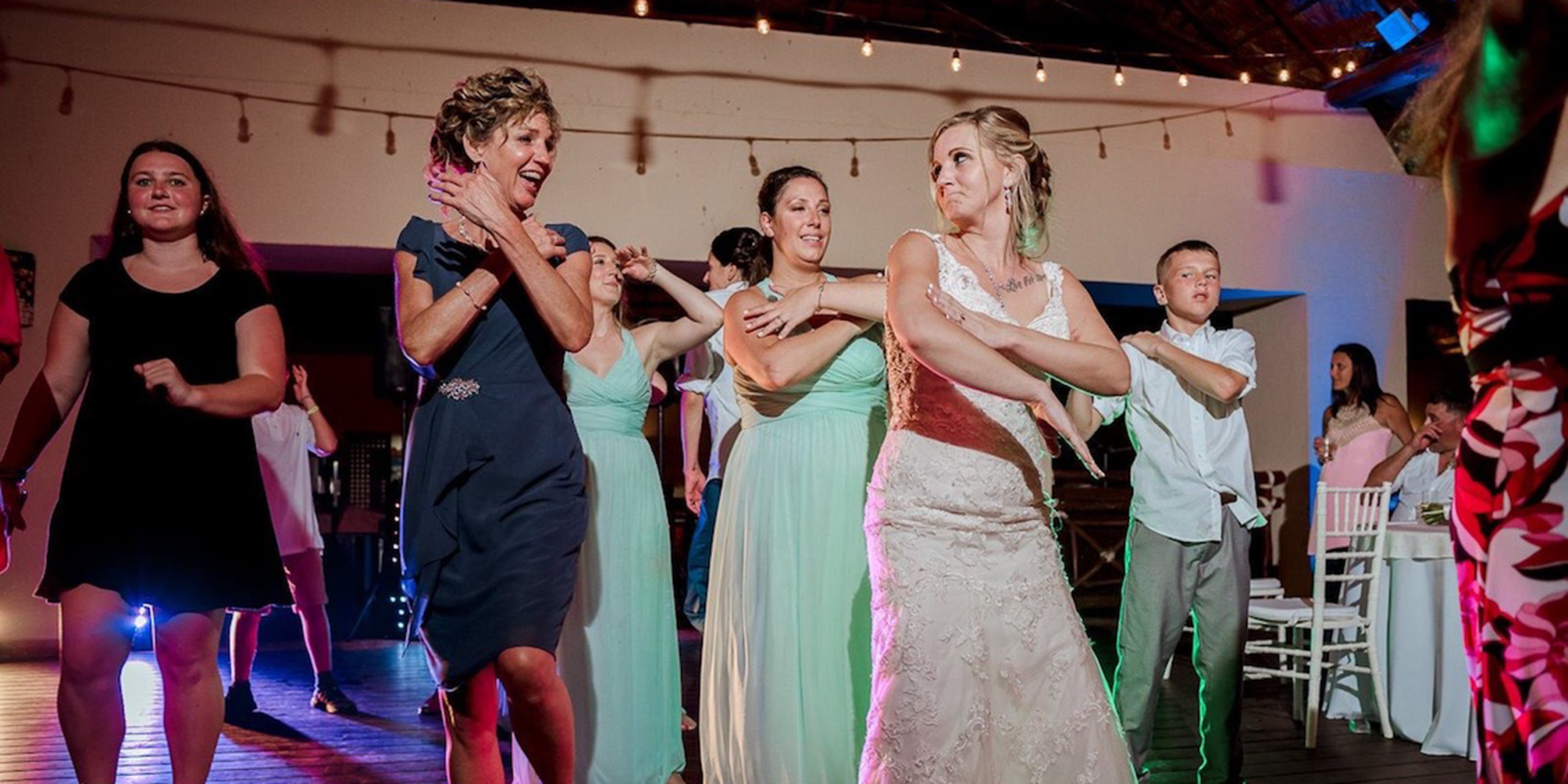 Tiana and Jessica line dance do the electric slide during their wedding reception