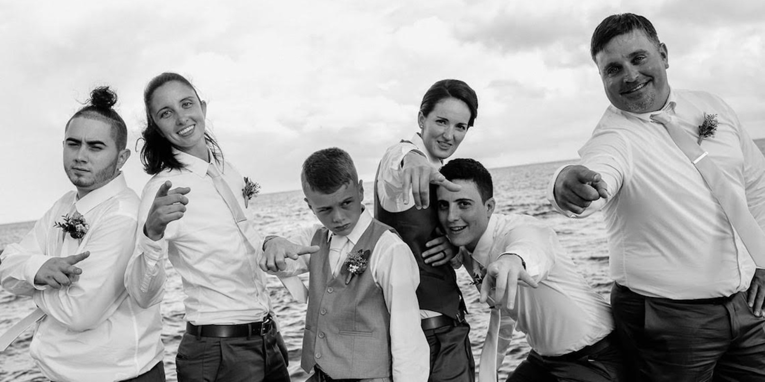Tiana and Jessica pose on the beach with their wedding party