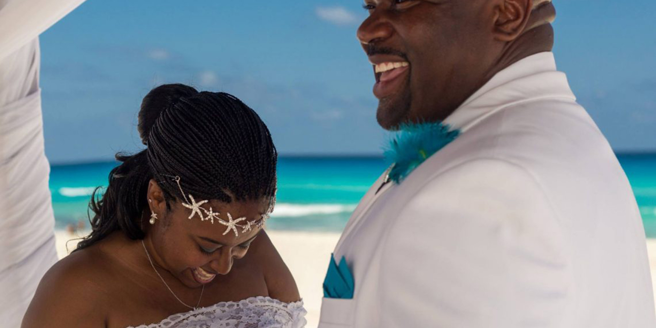Tiffanie and Troy smile while getting married on the beach