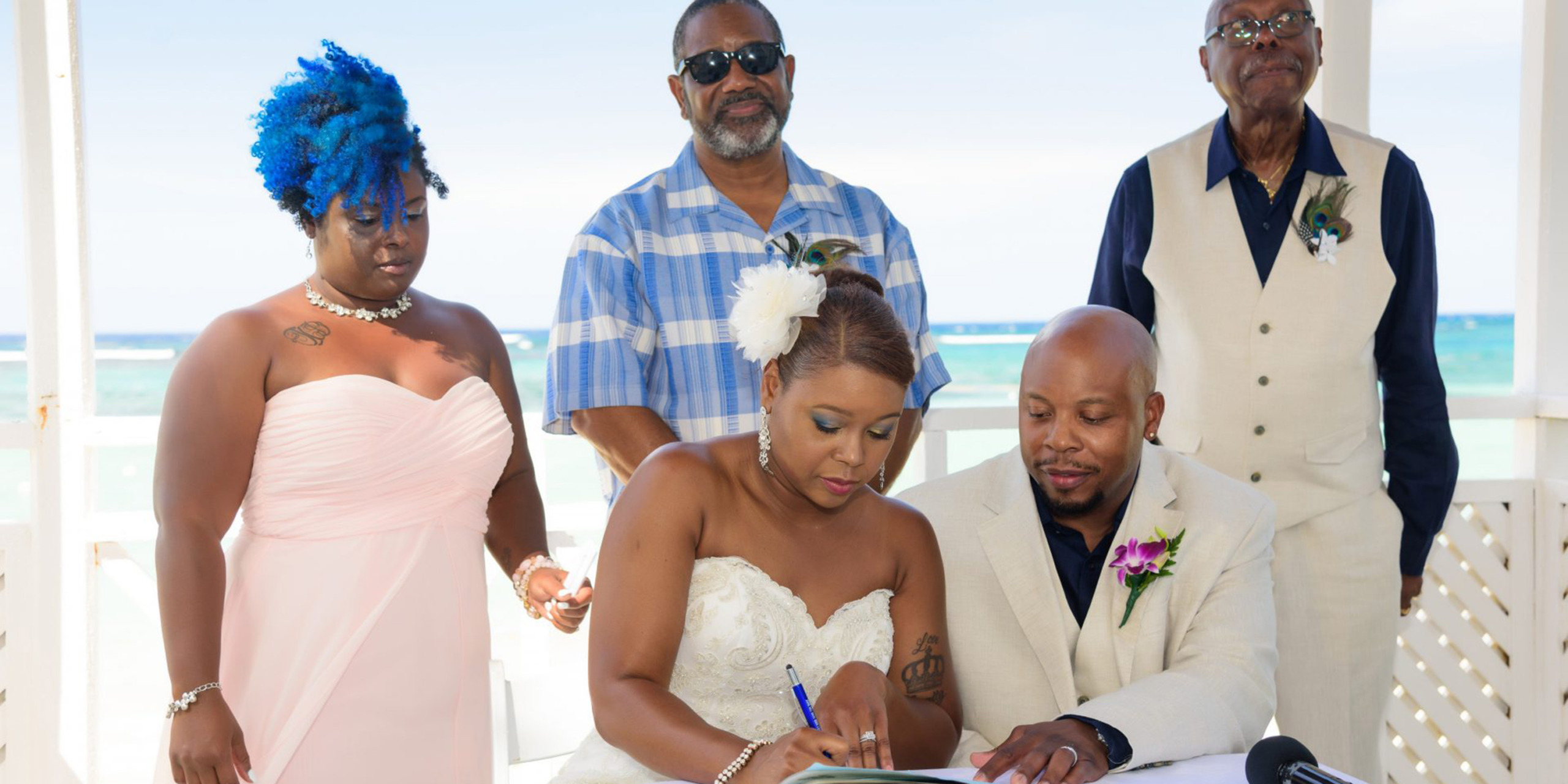 Tonya and Omar doing wedding paperwork during their wedding together.
