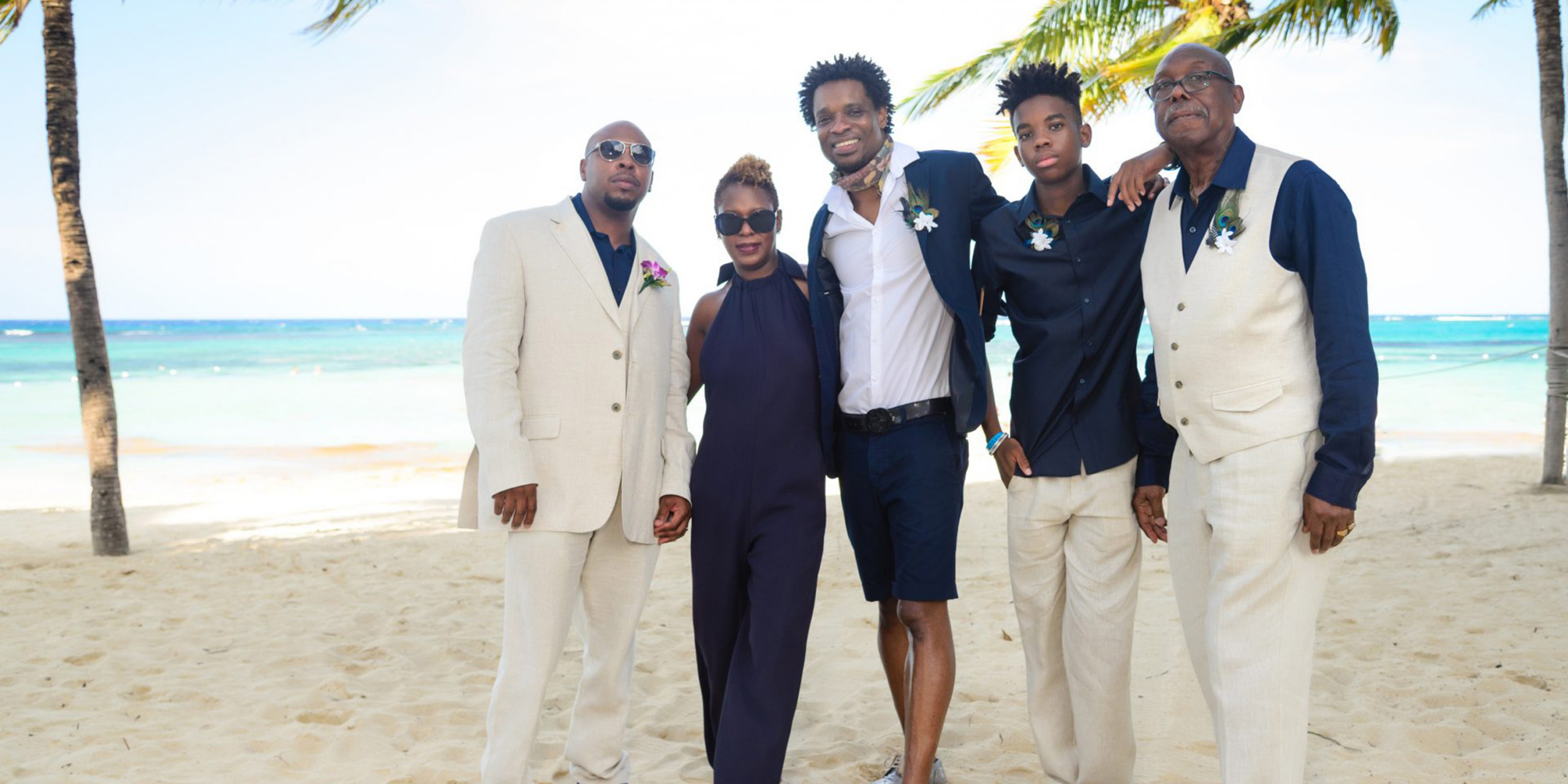 Omar poses with his family and friends on the beach at the Destify destination Tonya and Omar wedding