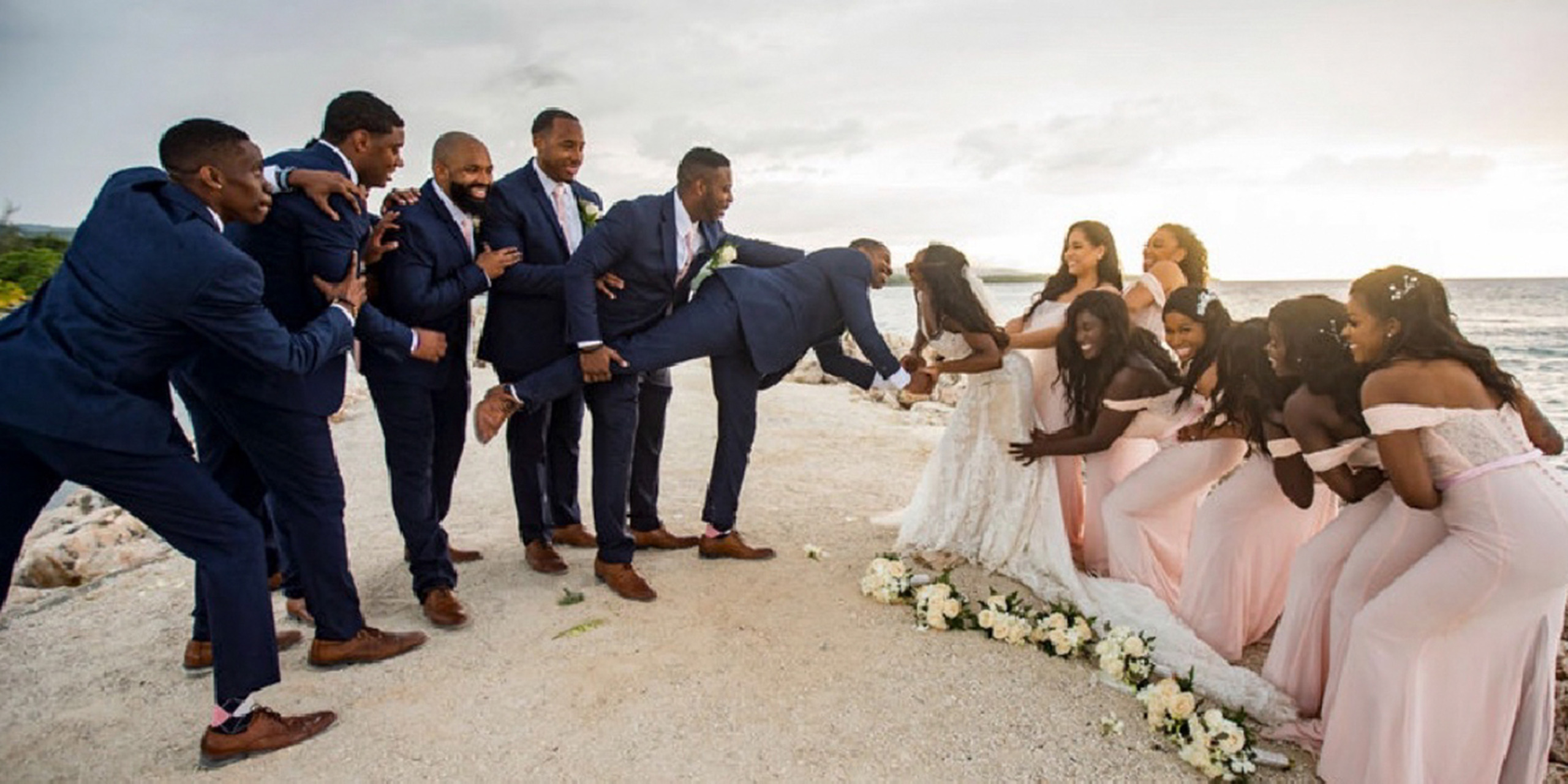 The entire wedding party groomsmen and bridesmaids celebrate at Wokie and James kiss