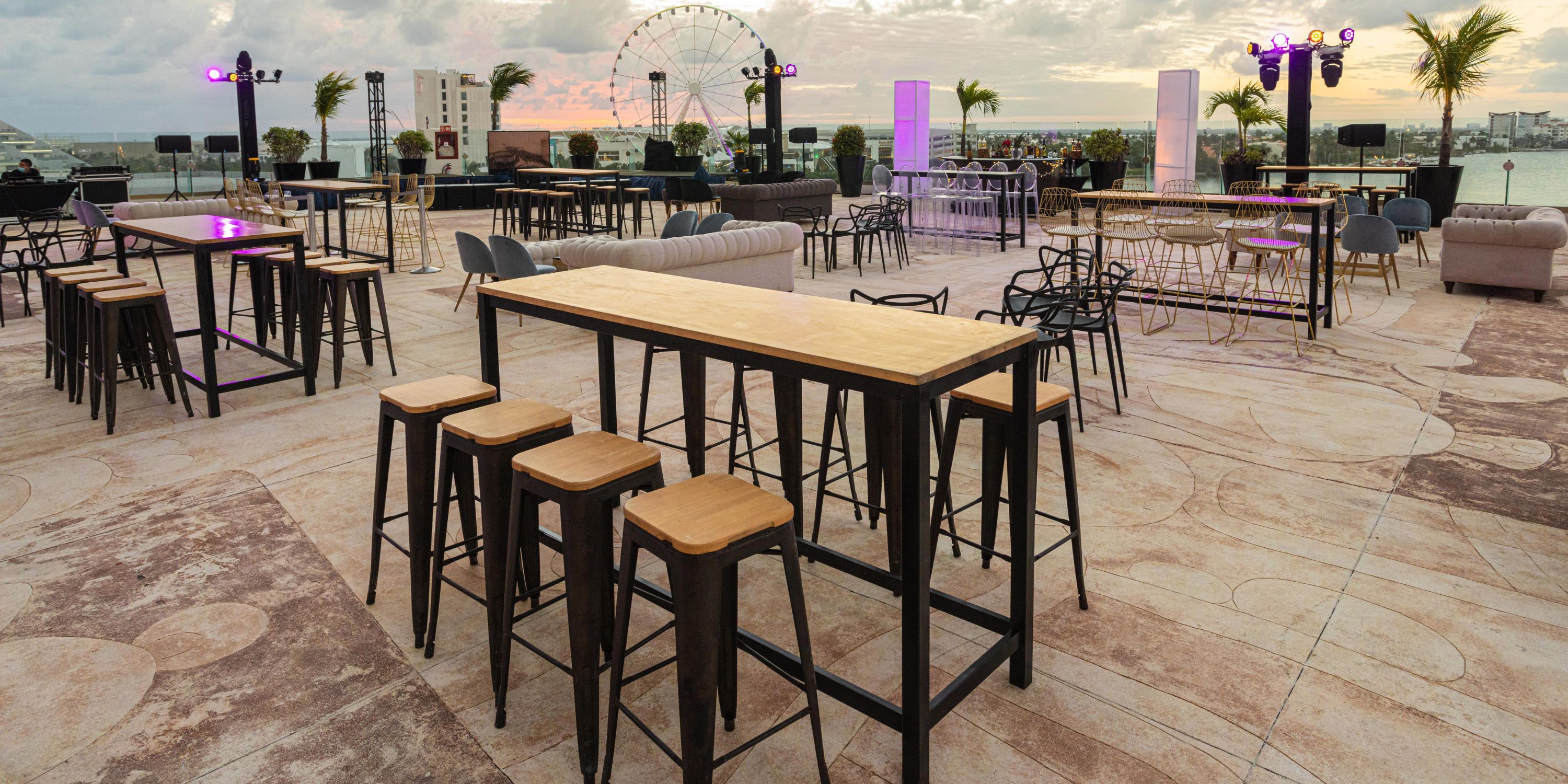 Beach Palace Cancun: Rooftop venue with wood tables and lounge seating, perfect for a destination wedding at sunset.