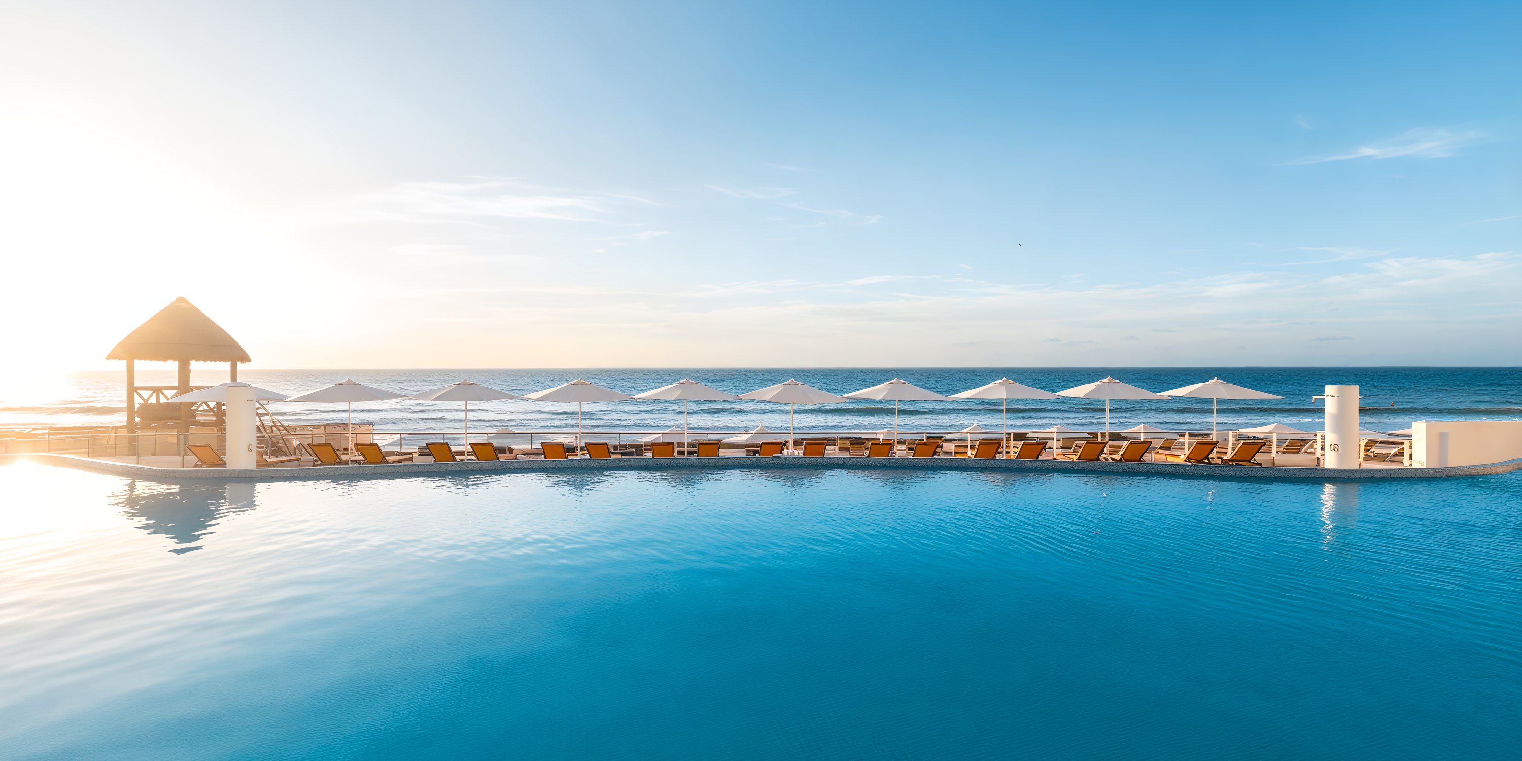Imagine a destination wedding at Beach Palace Cancun, where you can relax by the infinity pool with loungers and umbrellas, all while enjoying a breathtaking view of the ocean at sunset.