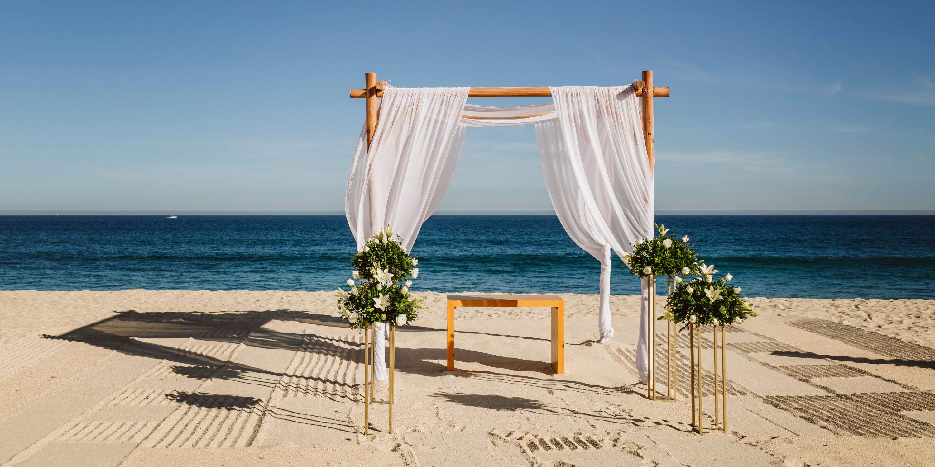 Le Blanc Spa Resort Los Cabos: Elegant destination wedding altar on the beach, draped in white and florals.