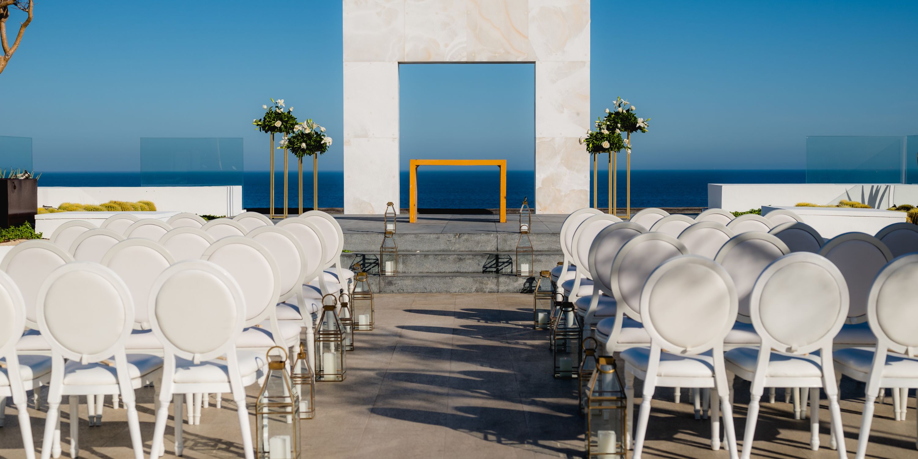 Rows of white chairs line up for a destination wedding by the ocean at Le Blanc Spa Resort Los Cabos.
