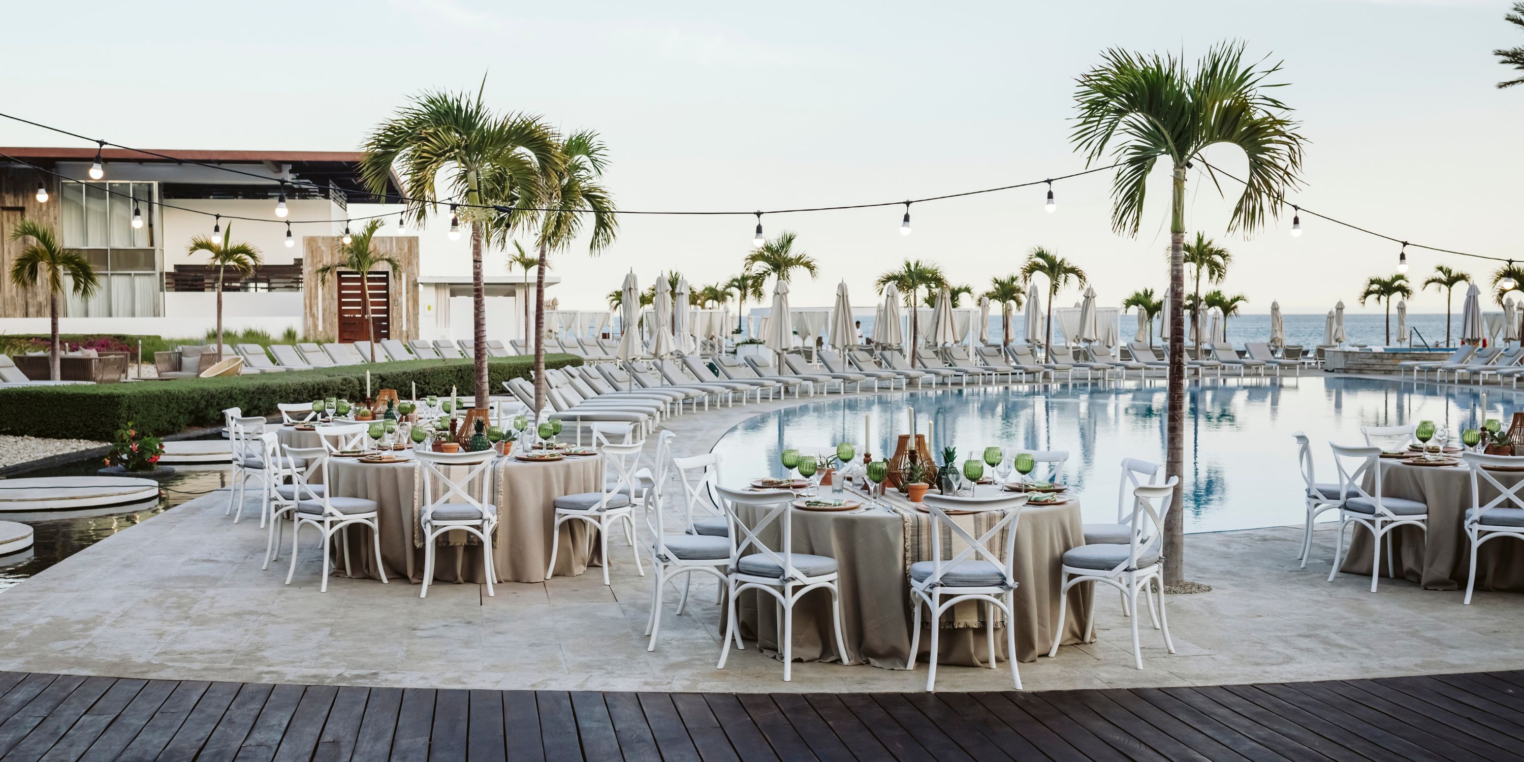 Le Blanc Spa Resort Los Cabos: poolside dining set up for a destination wedding with palm trees and lights.