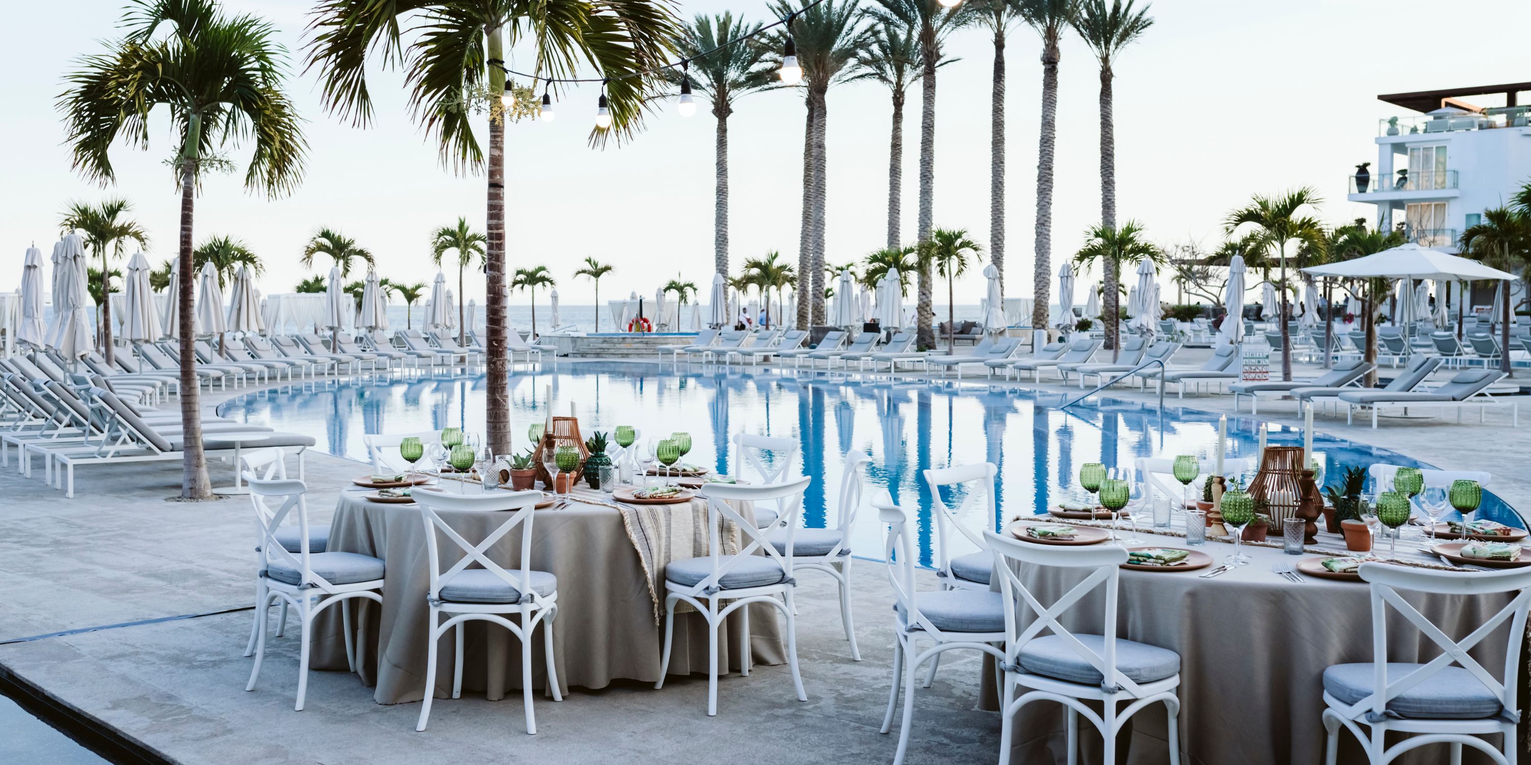 Dining tables by a large pool at Le Blanc Spa Resort Los Cabos, perfect for a destination wedding.