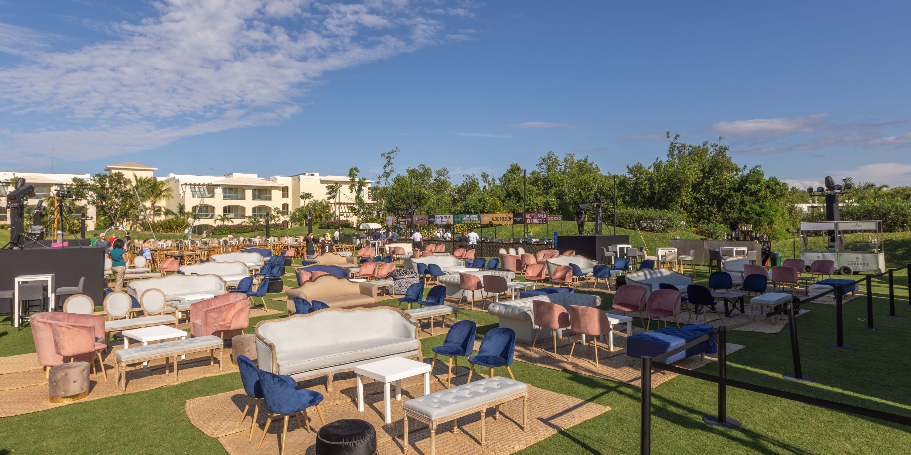 Moon Palace The Grand destination wedding setup outdoors with couches, chairs, and tables on grass.