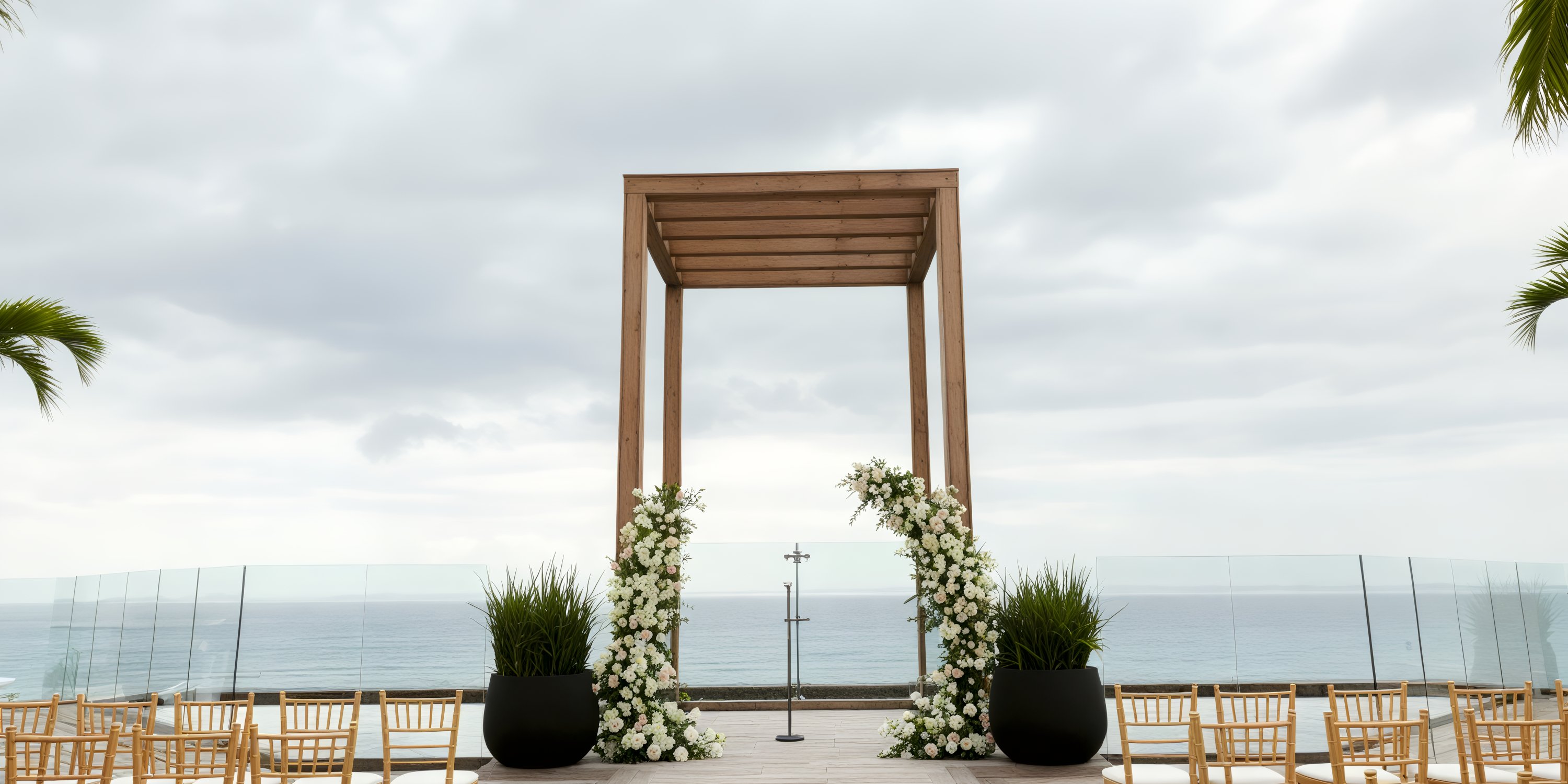 An outdoor altar adorned with floral decorations provides a stunning backdrop for a destination wedding, offering breathtaking views of the ocean.