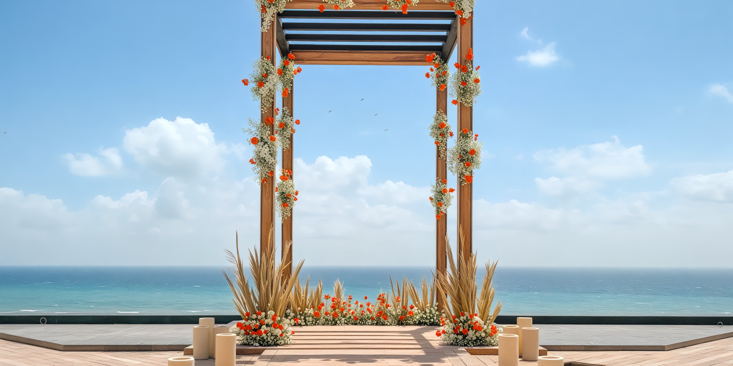 A beautiful wooden arch adorned with flowers overlooks the ocean and sky, creating a picturesque setting for a destination wedding. The scene is further enhanced by the gentle glow of candles surrounding the area.
