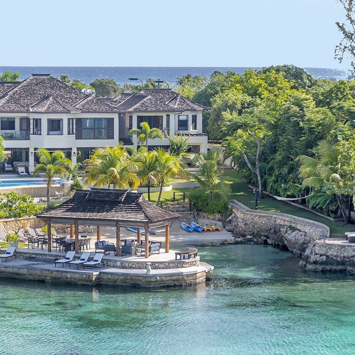Luxurious Starfish Discovery Bay perfect for a destination wedding, with a thatched gazebo, outdoor pool, and lush greenery by the blue ocean.