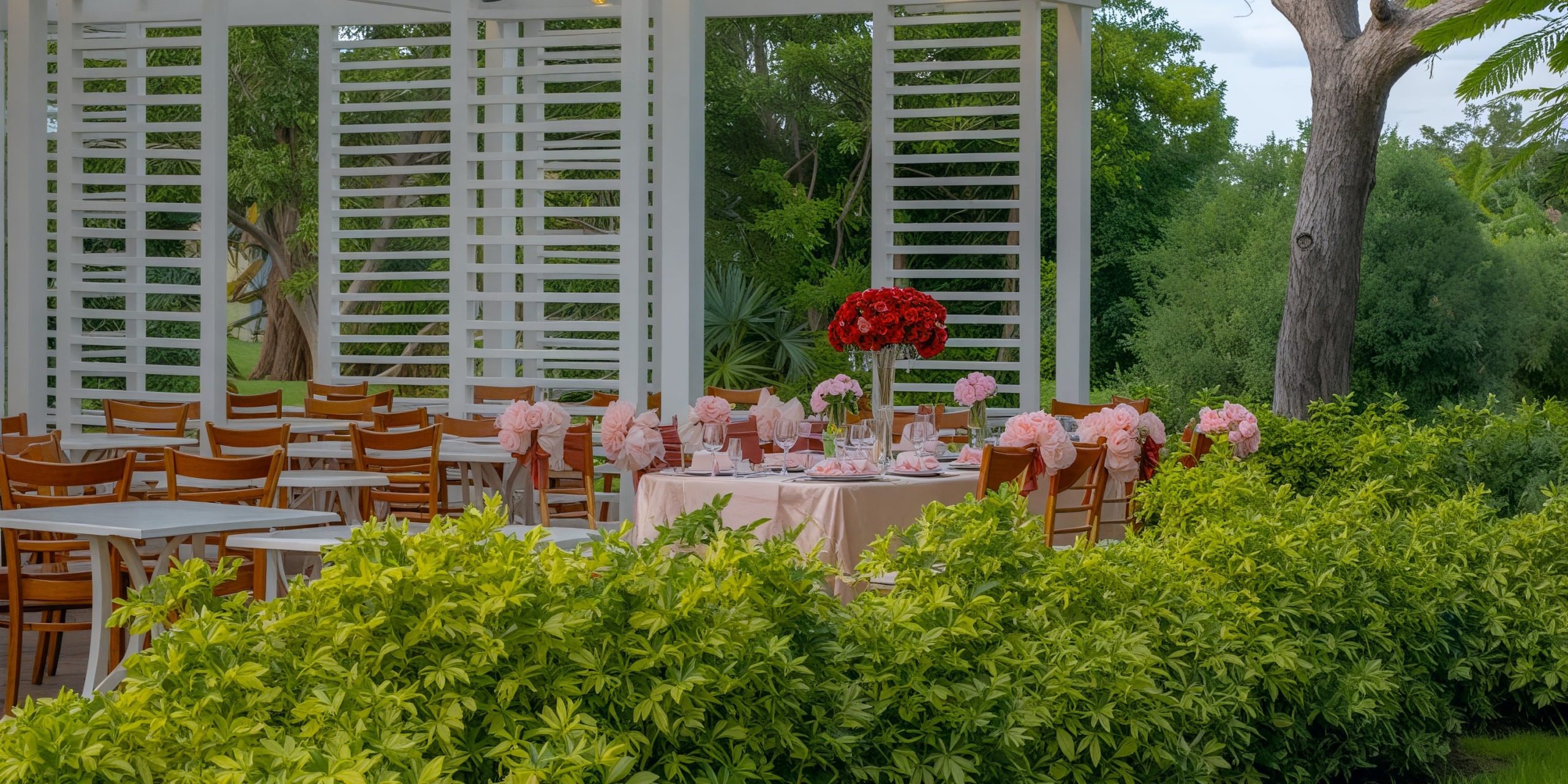 The Viva Wyndham Fortuna Beach offers a stunning destination wedding setup, complete with elegantly decorated tables and chairs nestled amidst lush green foliage.