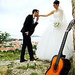 Guitar in the foreground of a man kissing his wife's hand music for your destination wedding