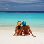 Couple sitting on the beach during a relaxing moment of their destination wedding schedule