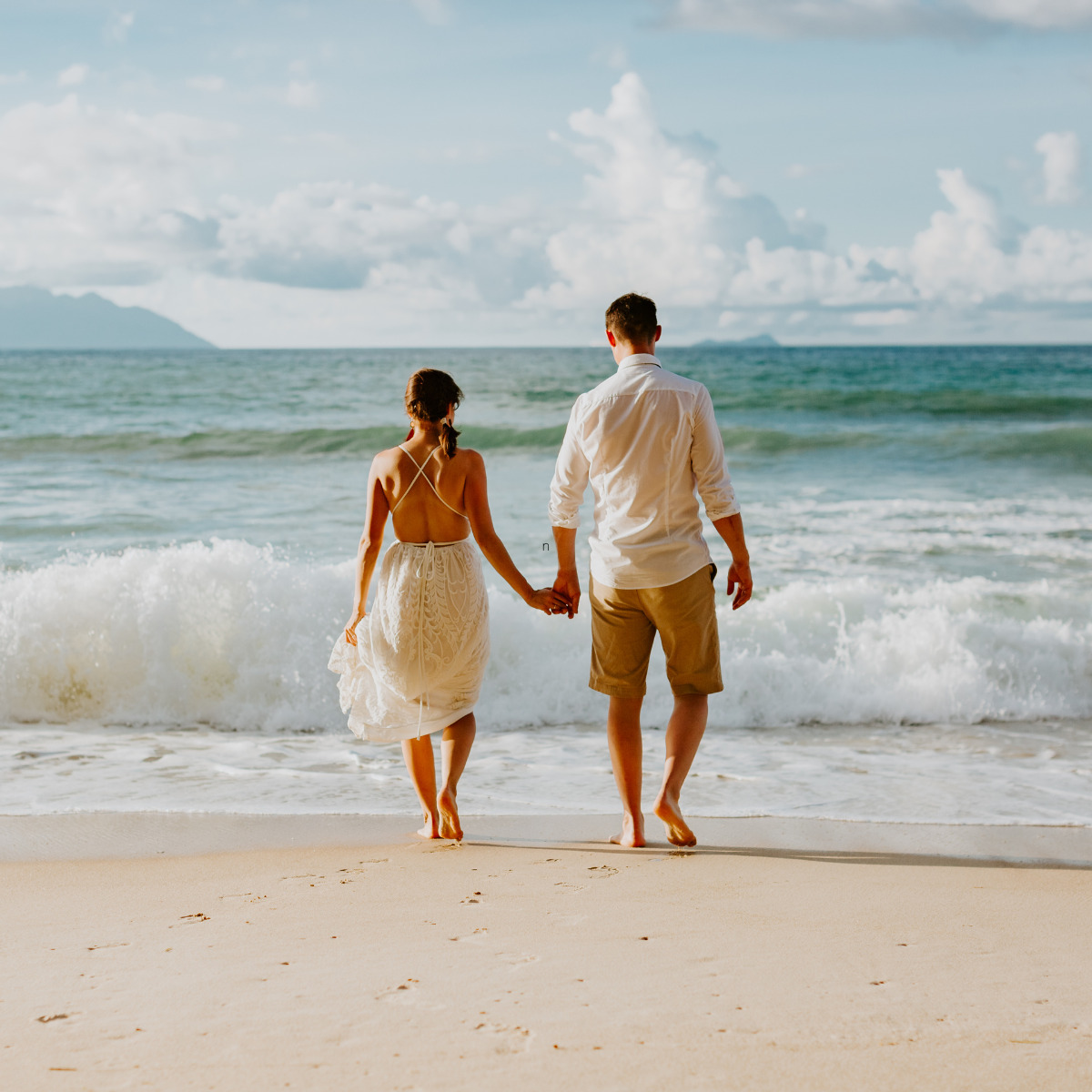 A couple holding hands on the beach after their Caribbean Islands destination wedding