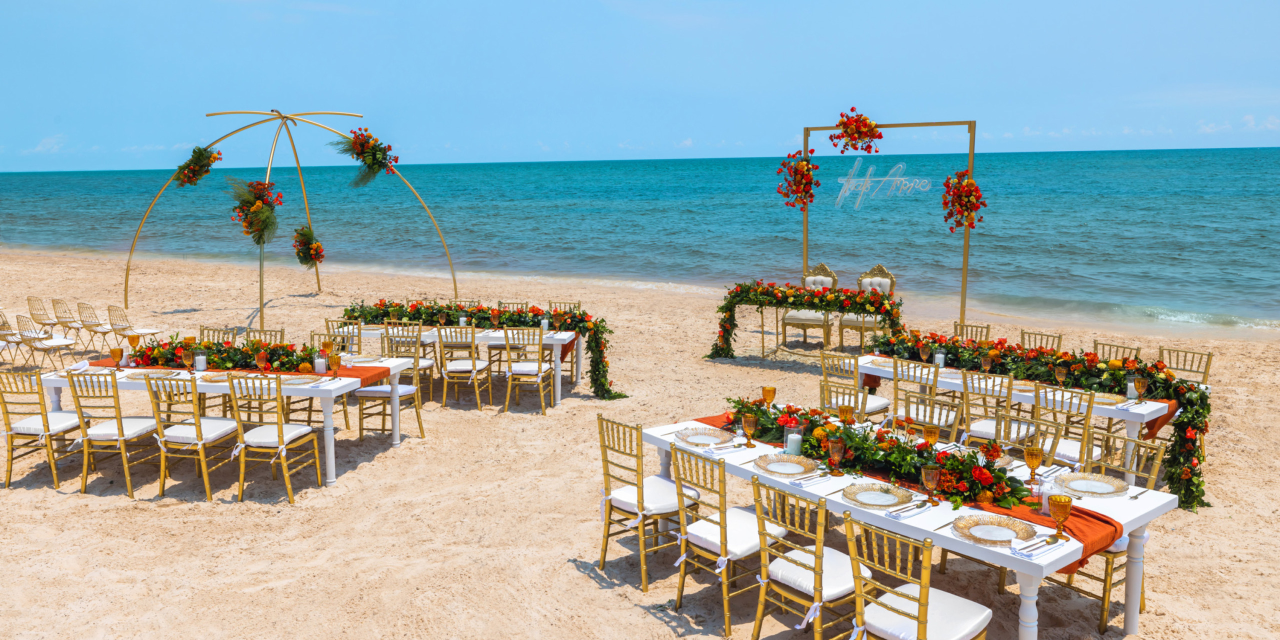 A beautifully arranged destination wedding at the Royalton Splash Riviera Cancun, featuring elegantly decorated chairs and tables on the beachfront.