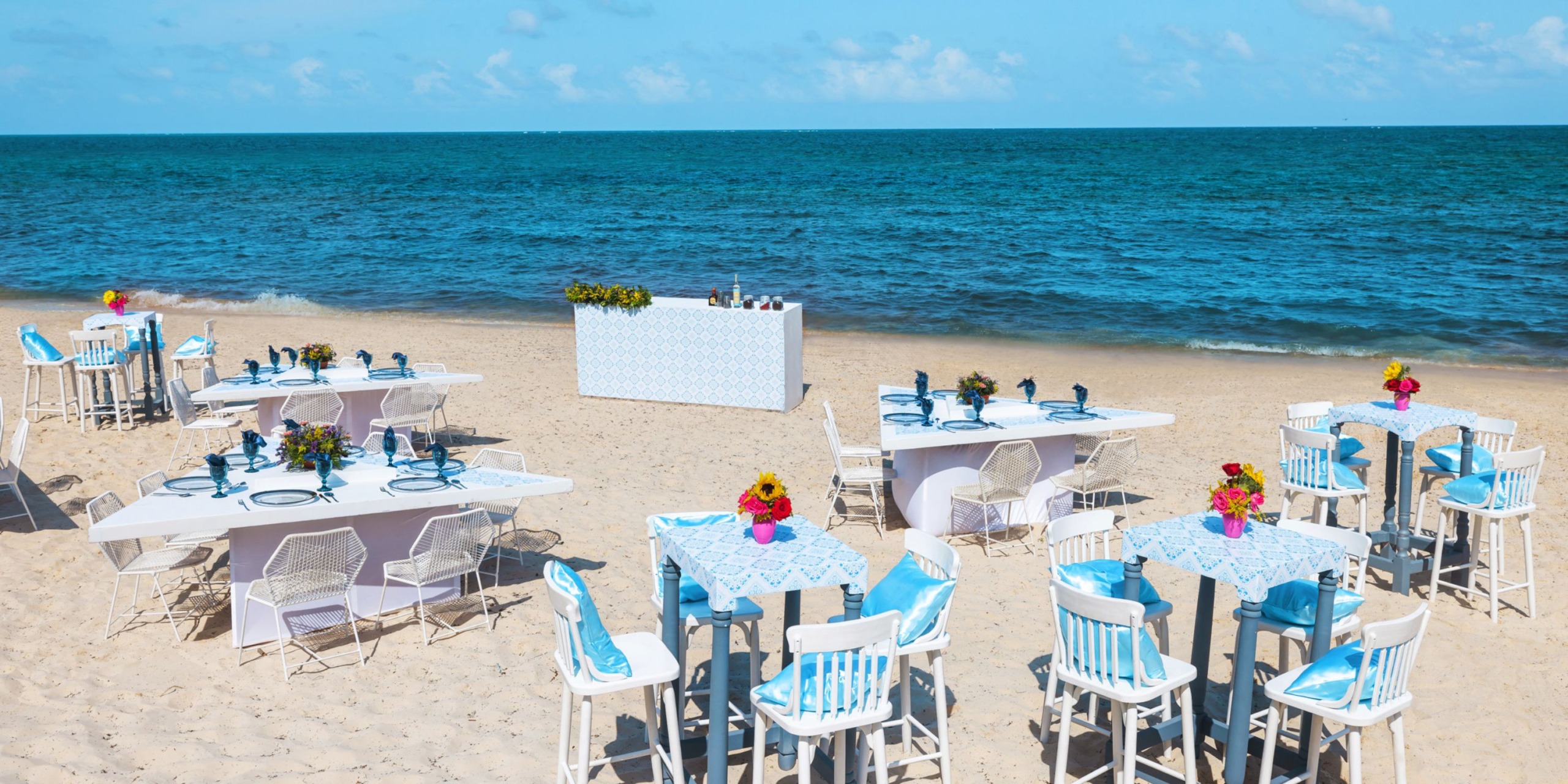 Royalton Splash Riviera Cancun: A breathtaking beachside setup, complete with tables and chairs overlooking the ocean, perfect for an unforgettable destination wedding.