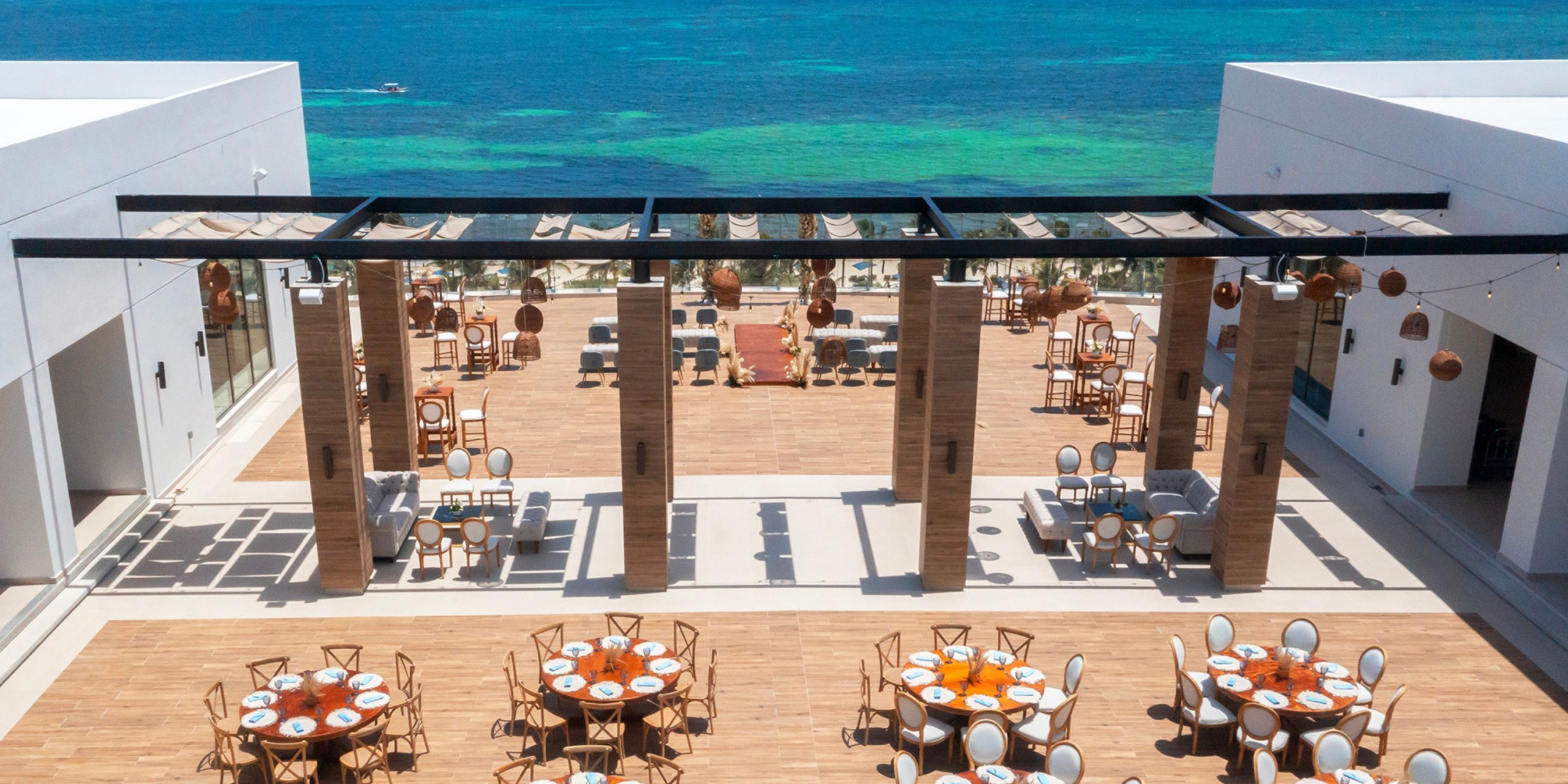 Experience outdoor dining at Royalton Splash Riviera Cancun, where tables offer breathtaking views of the clear blue ocean, creating an idyllic setting perfect for a destination wedding.