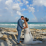 Gorgeous couple kissing on one of the best Mexico Wedding Venues with a rainbow in the distance